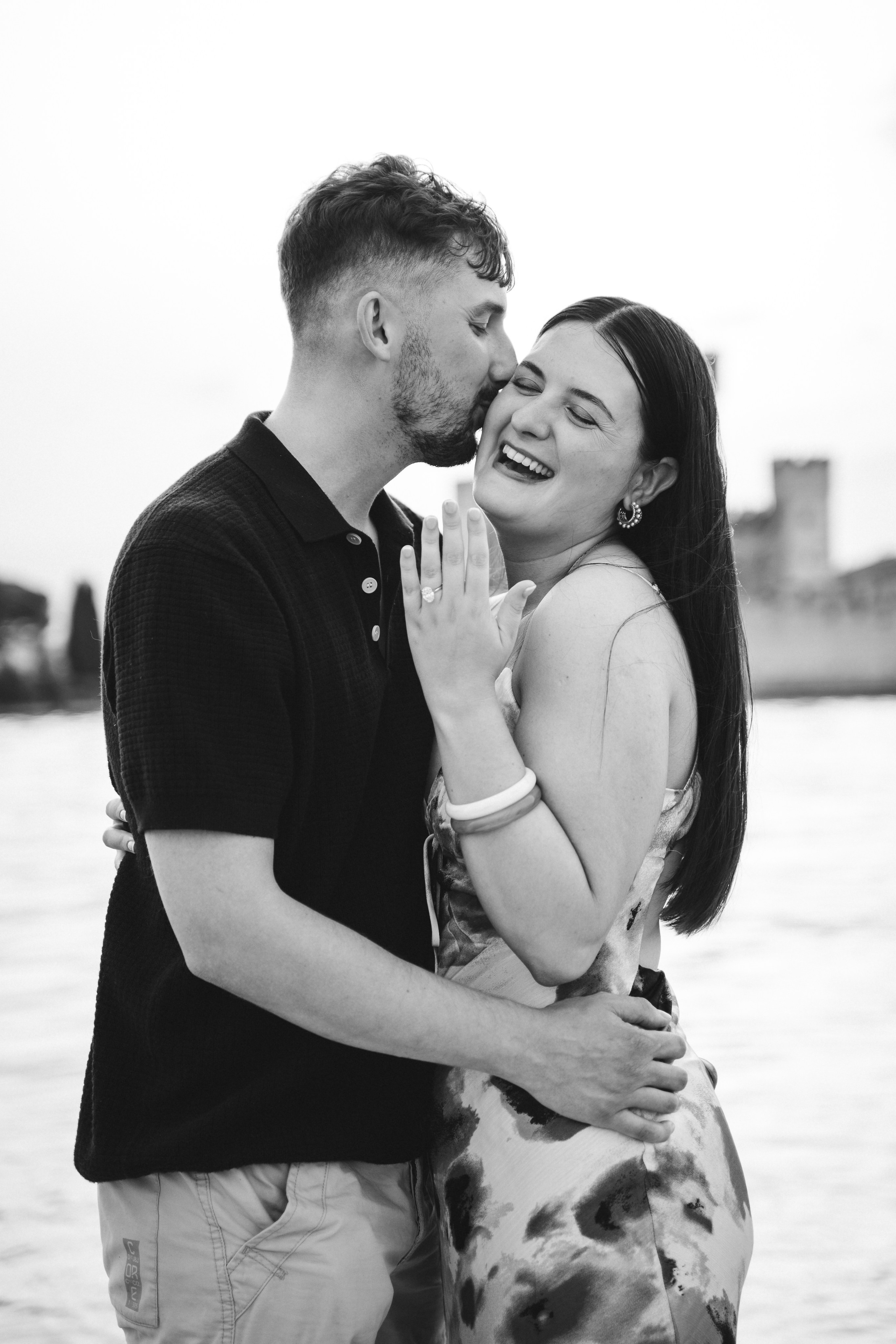 Candid laughter during an engagement photoshoot on the waters surrounding Sirmione.