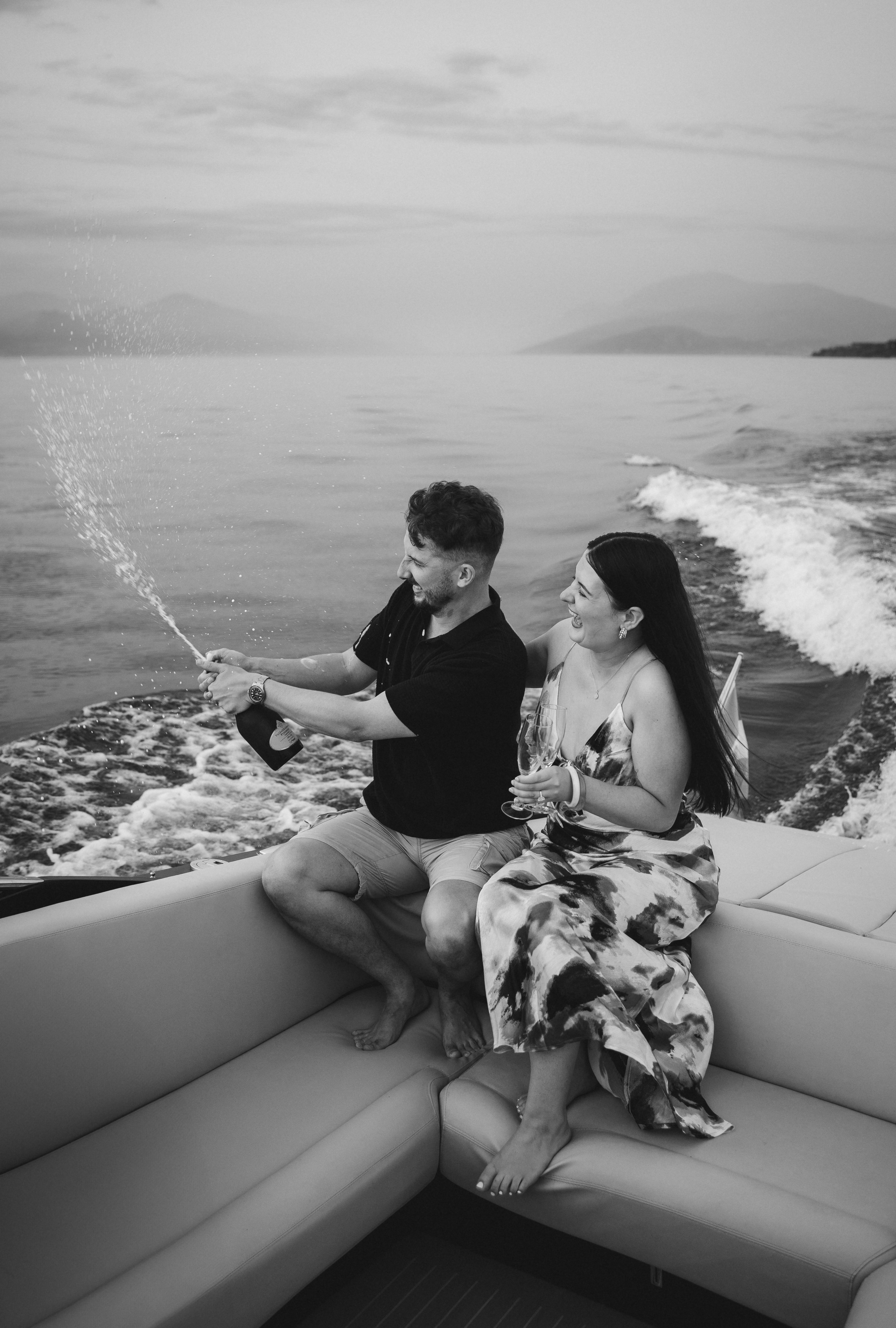 Romantic champagne celebration after a private boat proposal near Sirmione Castle at sunset.