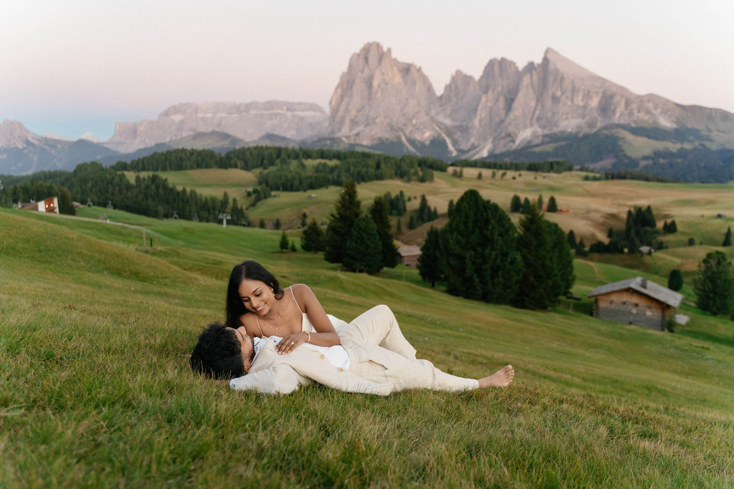 Newly engaged partners sharing a quiet moment with the Dolomites behind them.
