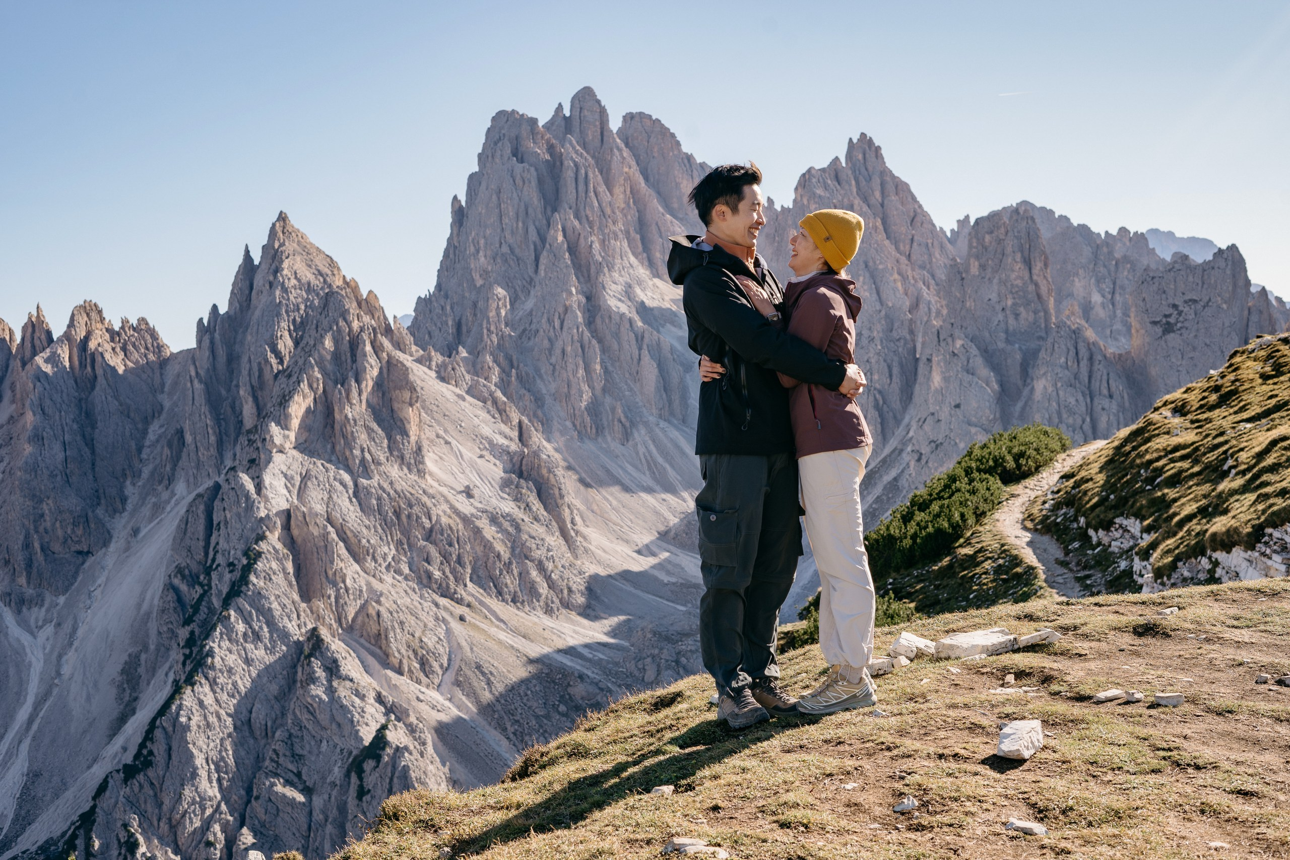 An Asian couple embracing after a surprise marriage proposal at Cadini di Misurina.