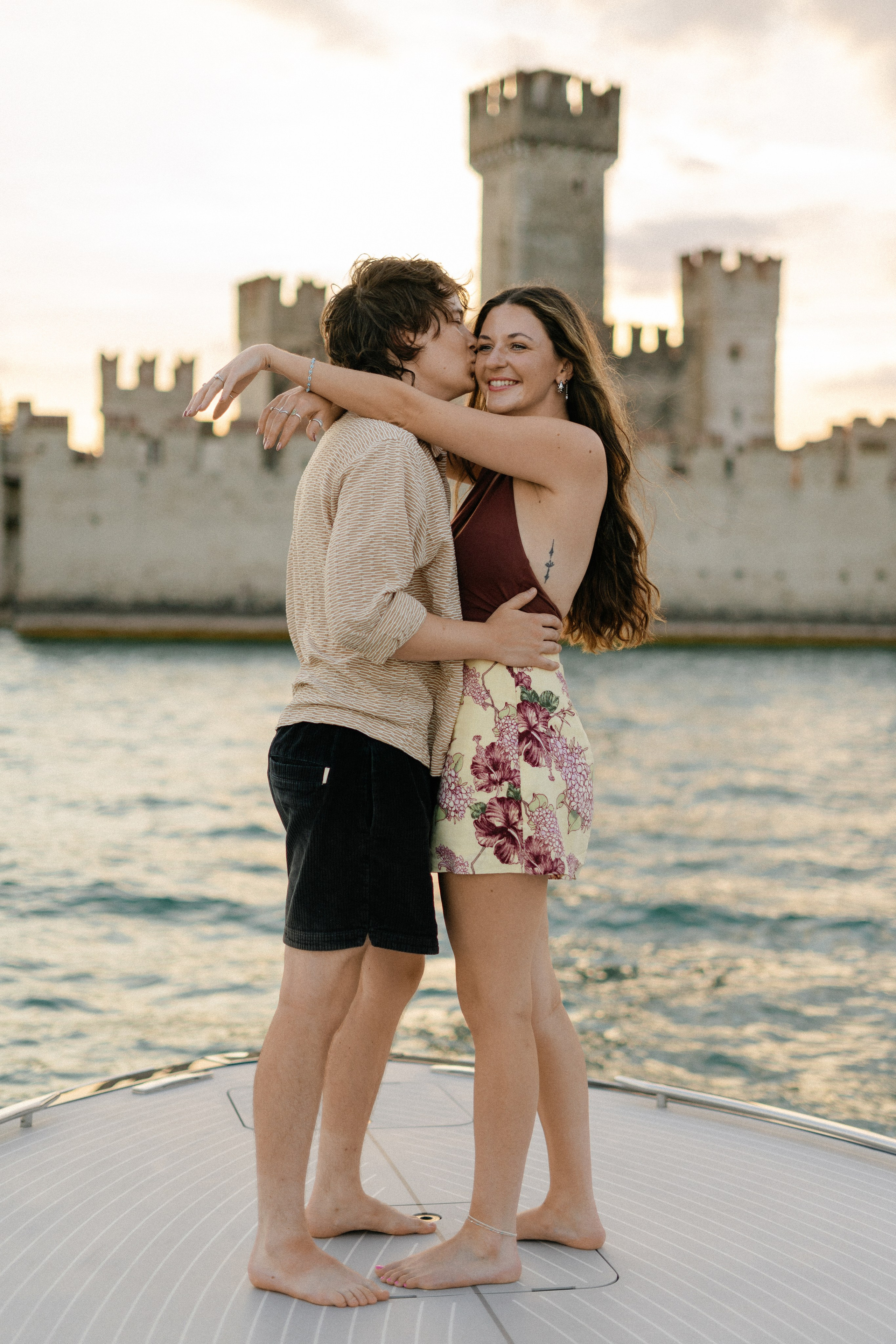 Lake Garda proposal photography at sunset on a luxury boat overlooking historic Sirmione.