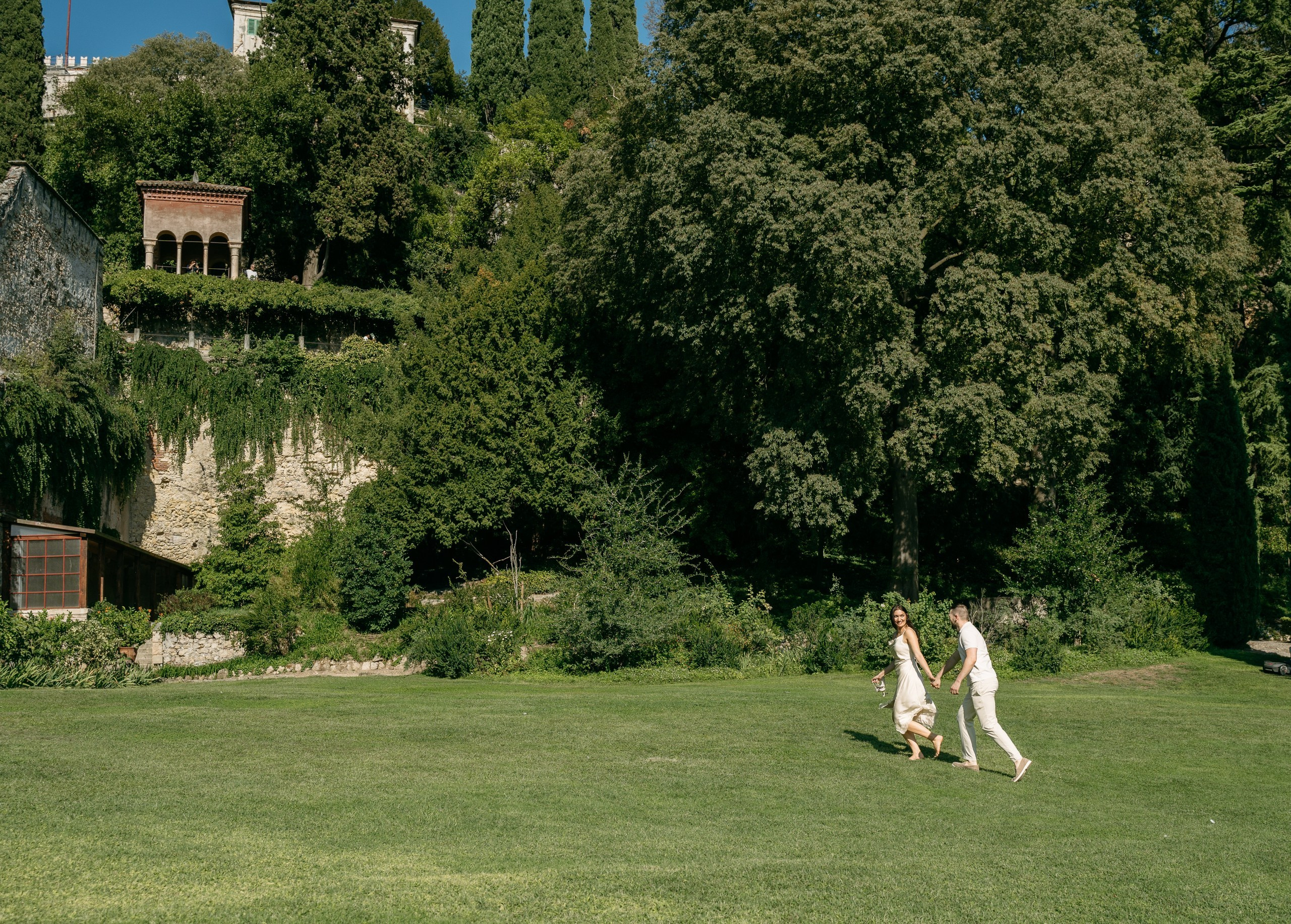 A couple walking together through Giardino Giusti after their marriage proposal.