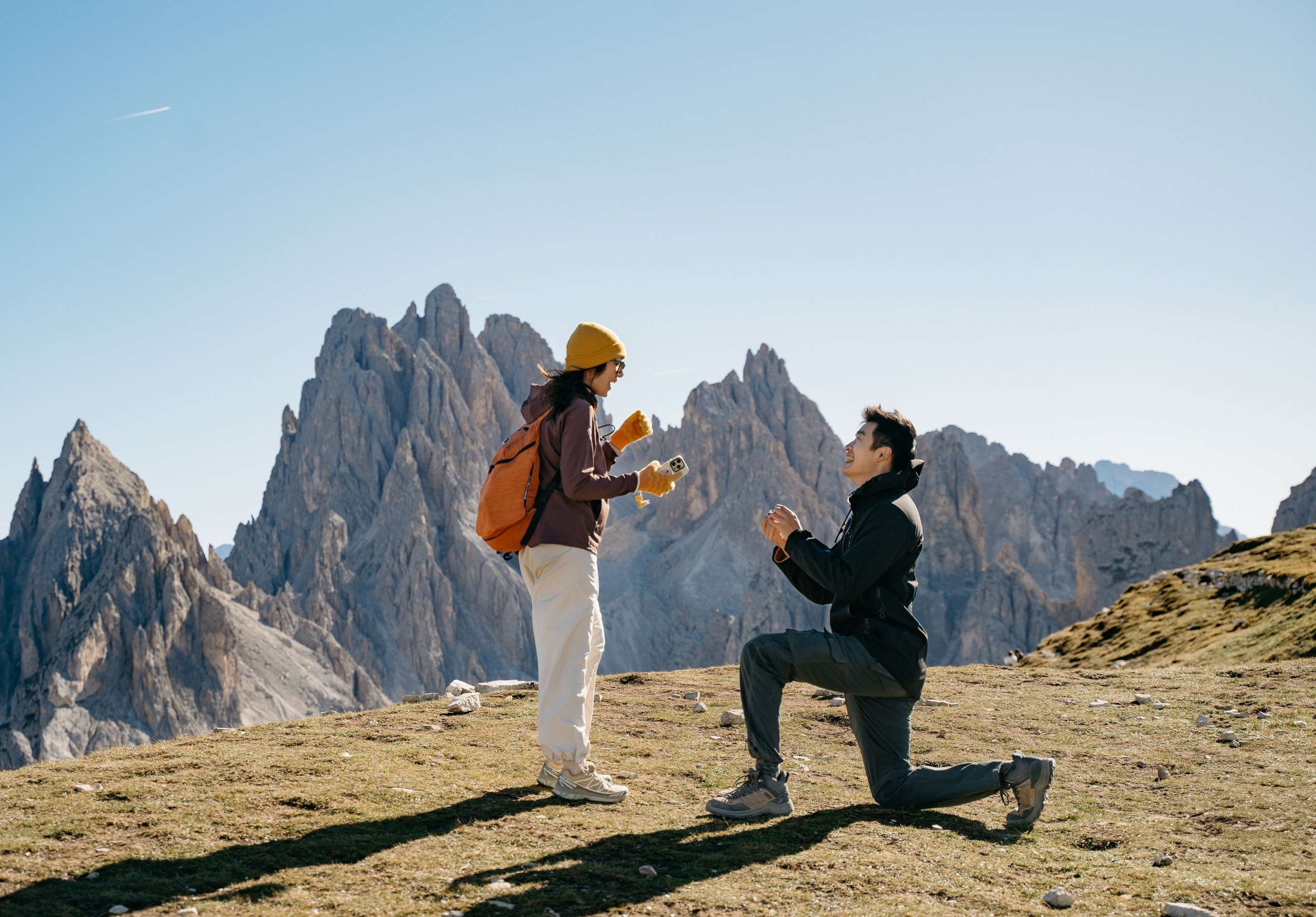 An Asian couple getting engaged at Cadini di Misurina, surrounded by the peaks of the Dolomites.