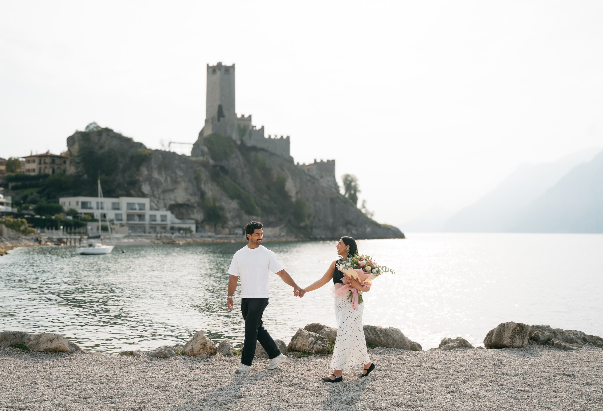 A marriage proposal with a flower bouquet overlooking Lake Garda in Malcesine.