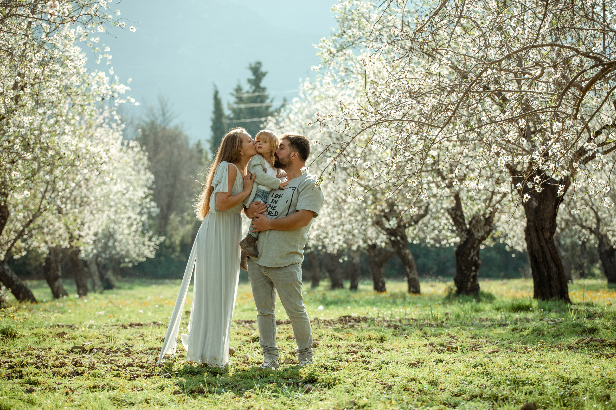 Family photo session in a flowering almond garden. Julia Ganch I Fashion Wedding Photography I Cappadocia Turkey