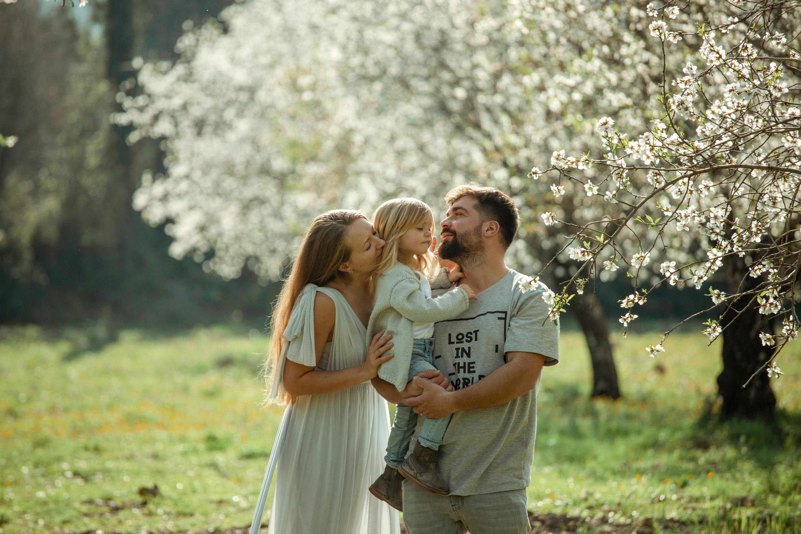 Family photo session in a flowering almond garden. Julia Ganch I Fashion Wedding Photography I Cappadocia Turkey