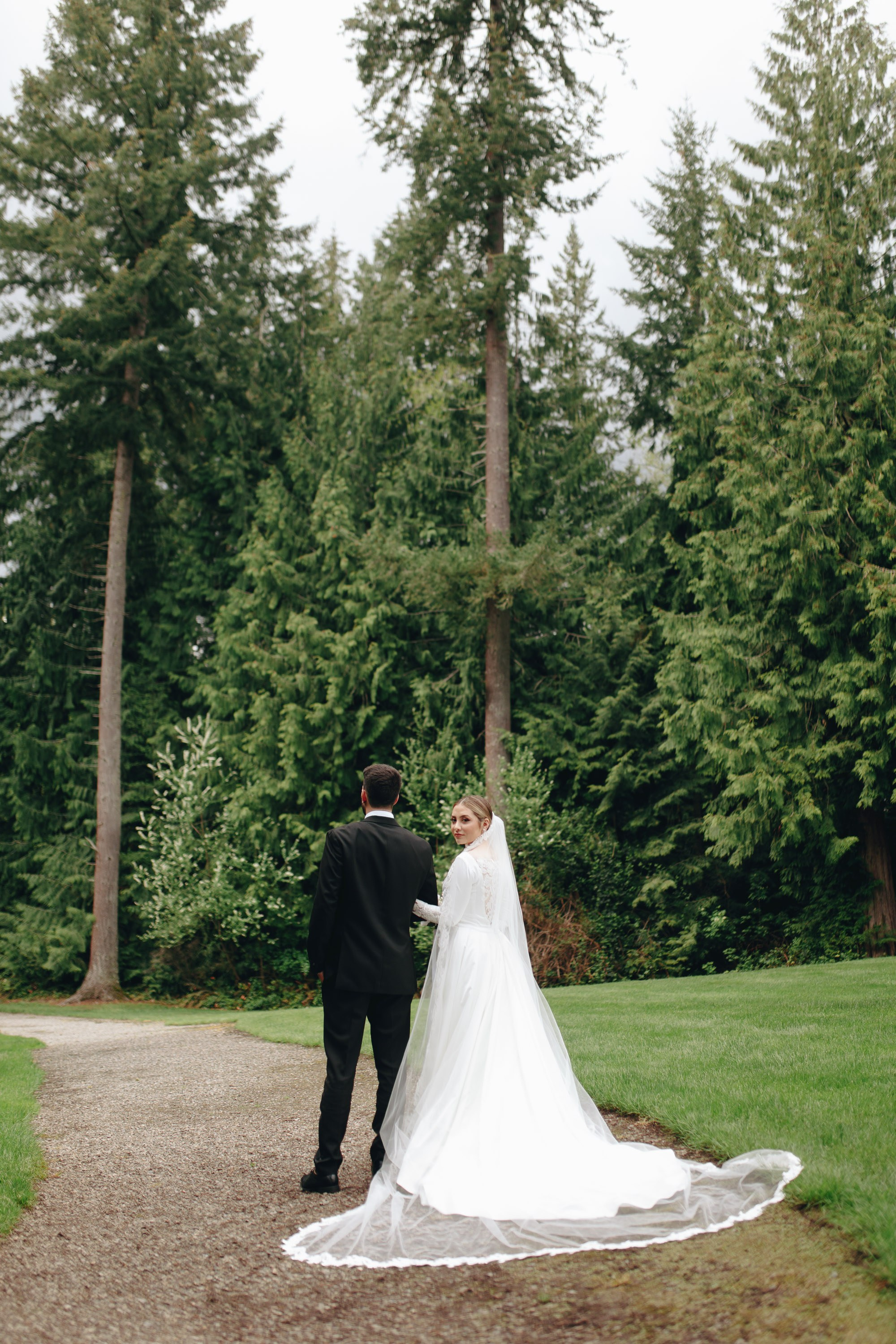Bride in white dress on grass, elegant full-length portrait