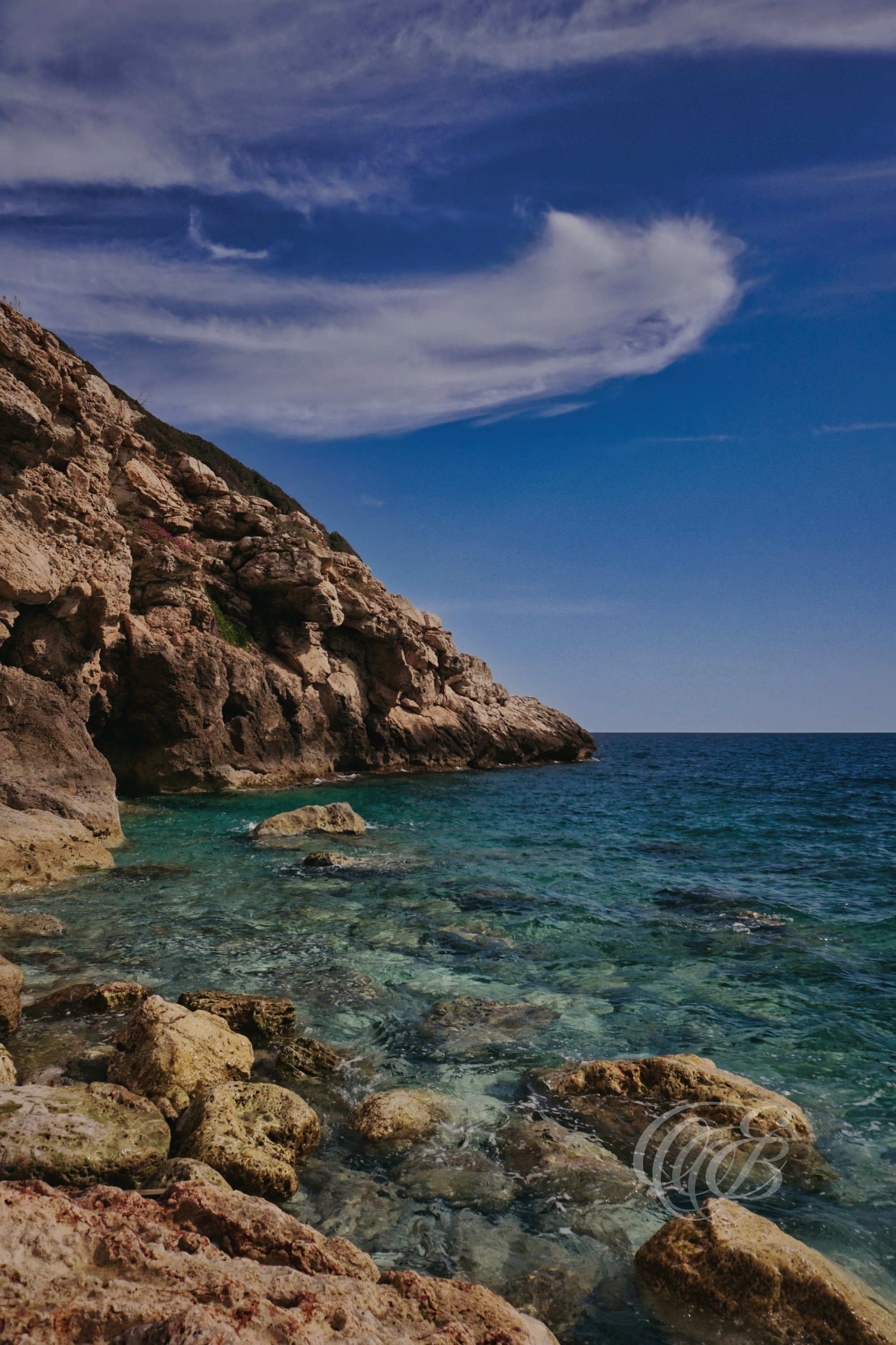 Punta des Grells Beach in spring, a coastal spot along Palma’s shoreline where rocky formations meet clear Mediterranean waters. The area reflects the island’s seasonal calm, with light changing across the sea and coastline as nature and urban edge meet. Eduardo Bartoli Photography.