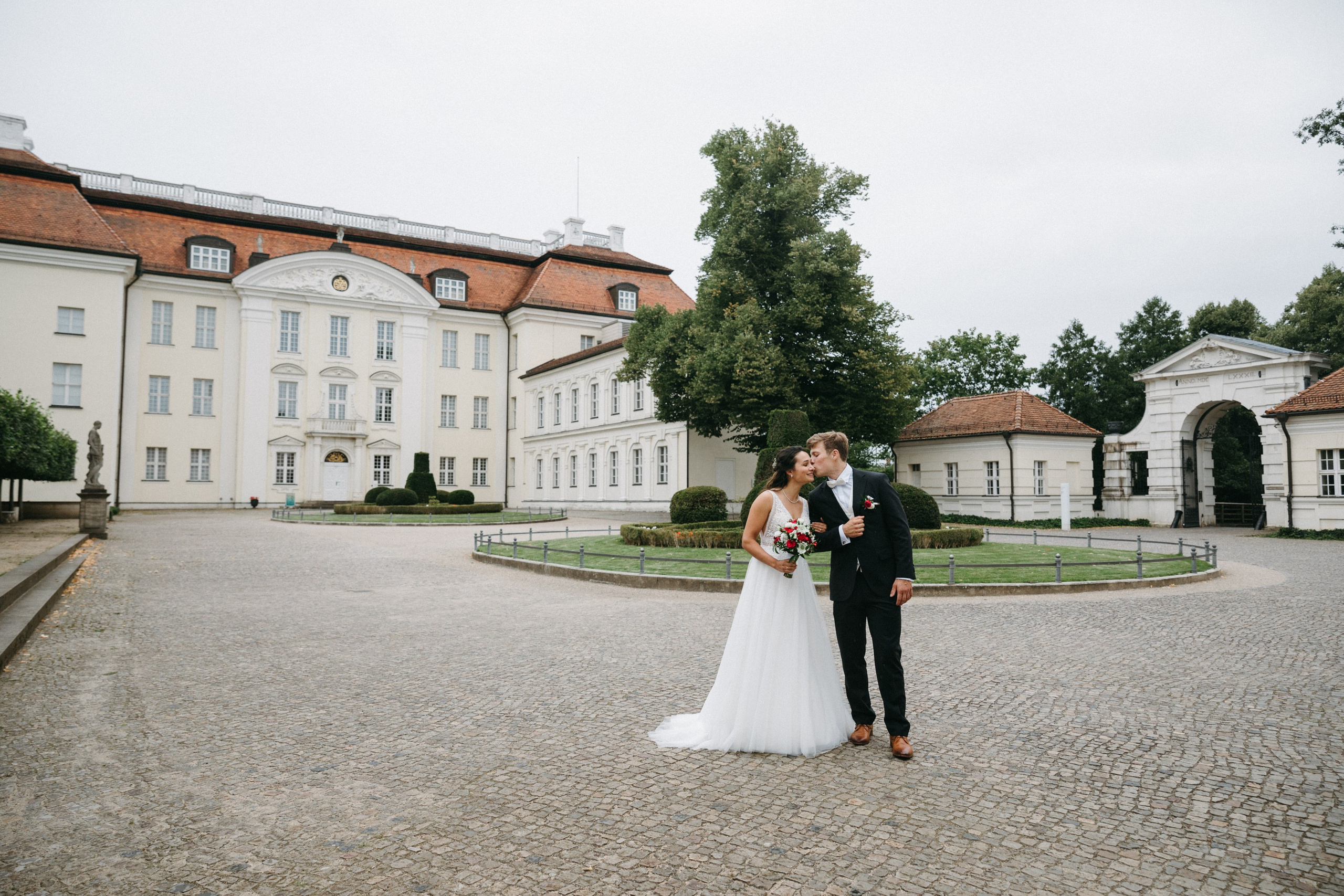 Romantischer Hochzeitskuss vor dem historischen Tor von Schloss Köpenick