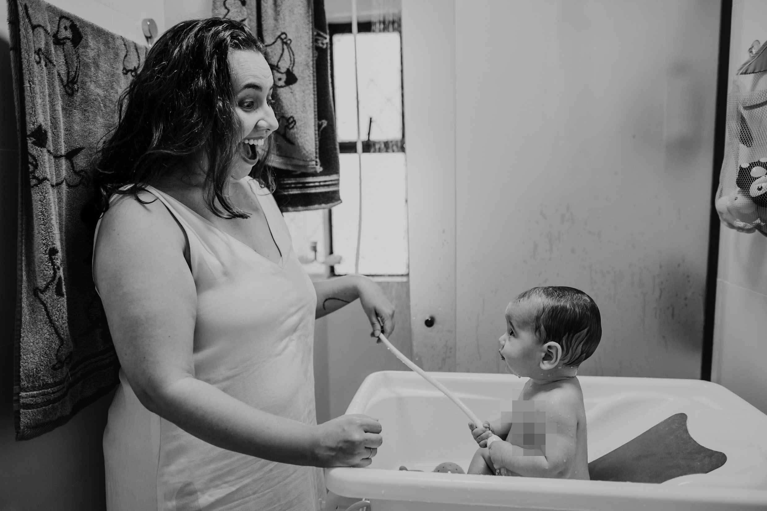 Mãe e bebê em cena afetiva durante ensaio em casa.