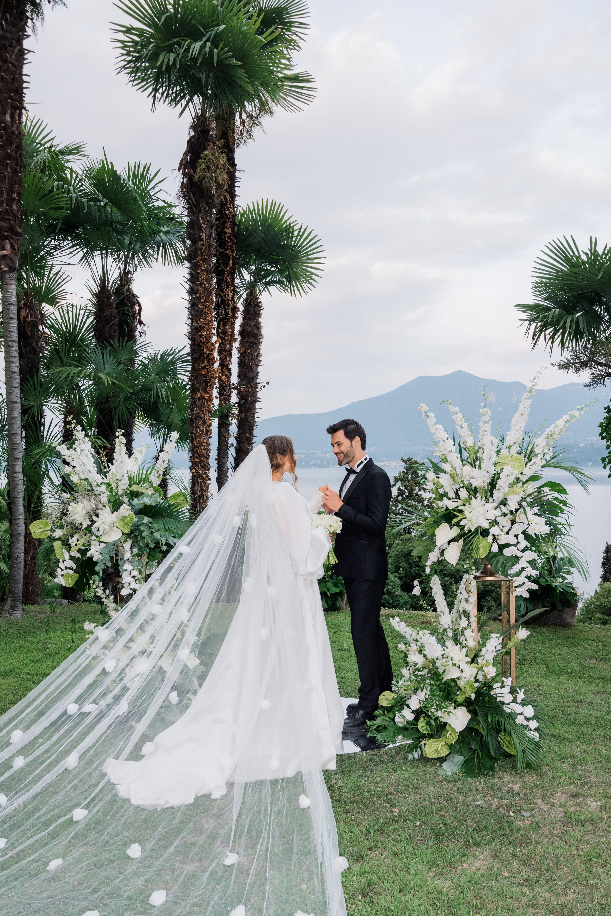 a bride and groom kissing in front of palm trees