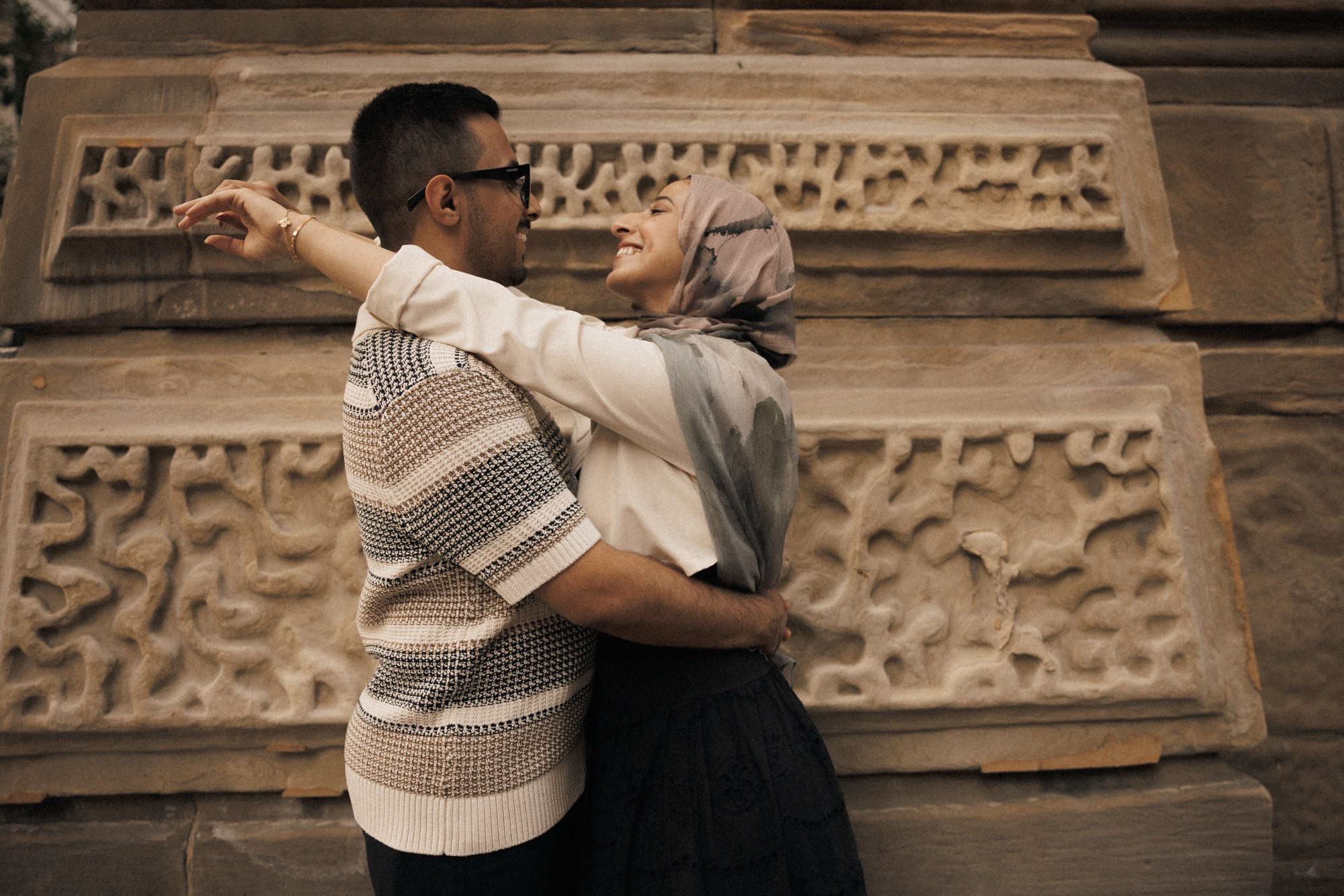 Couple embracing near historic stone wall in Montreal