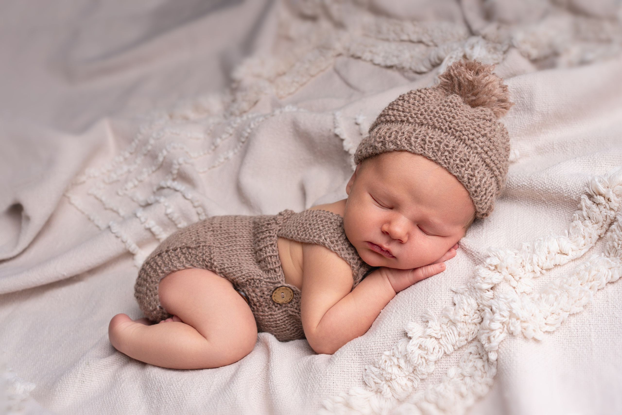 Neugeborenes Baby auf Bauch, sanft beleuchtet