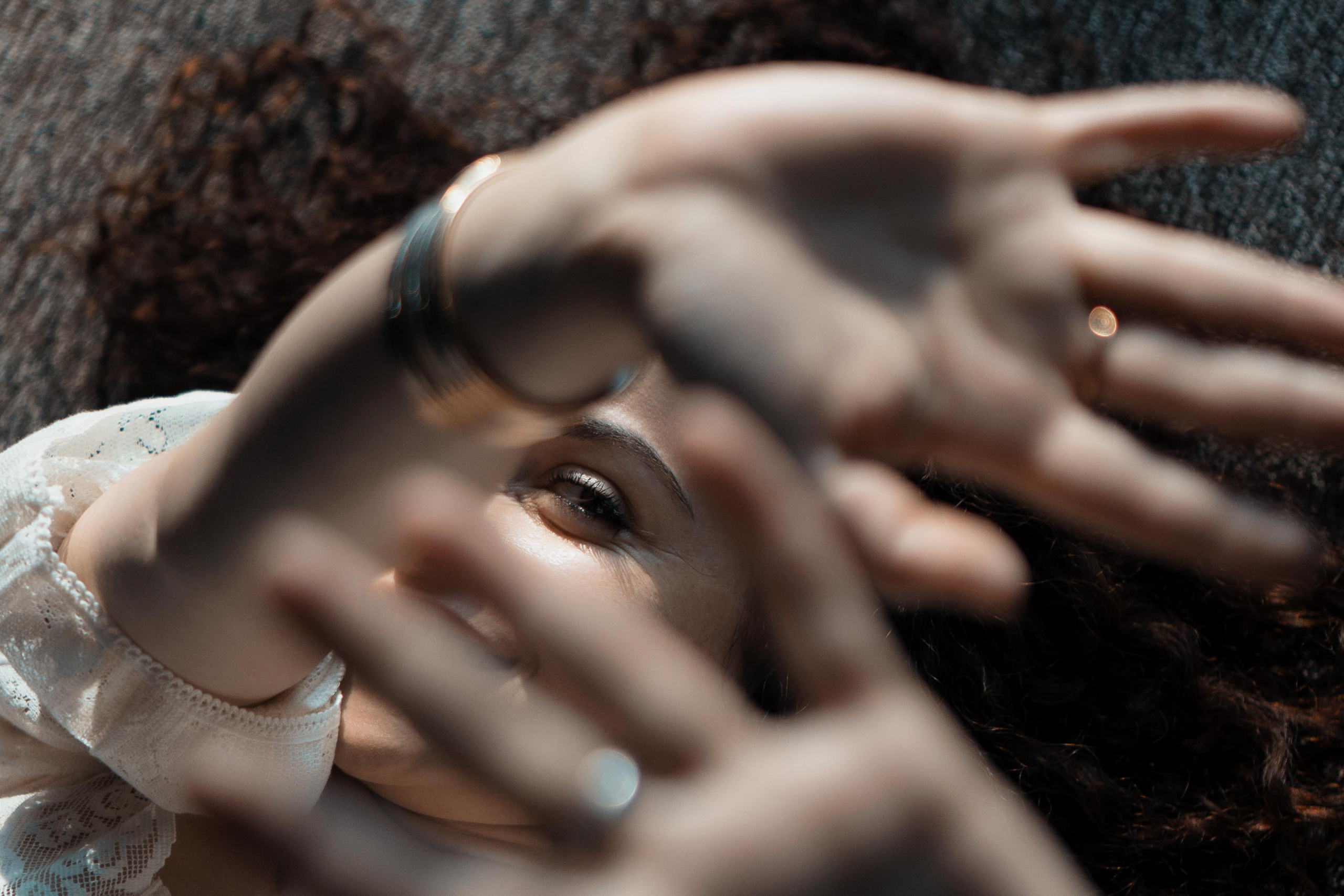 Verspieltes Portrait, Frau schaut durch Hände hindurch – kreative Fotografie