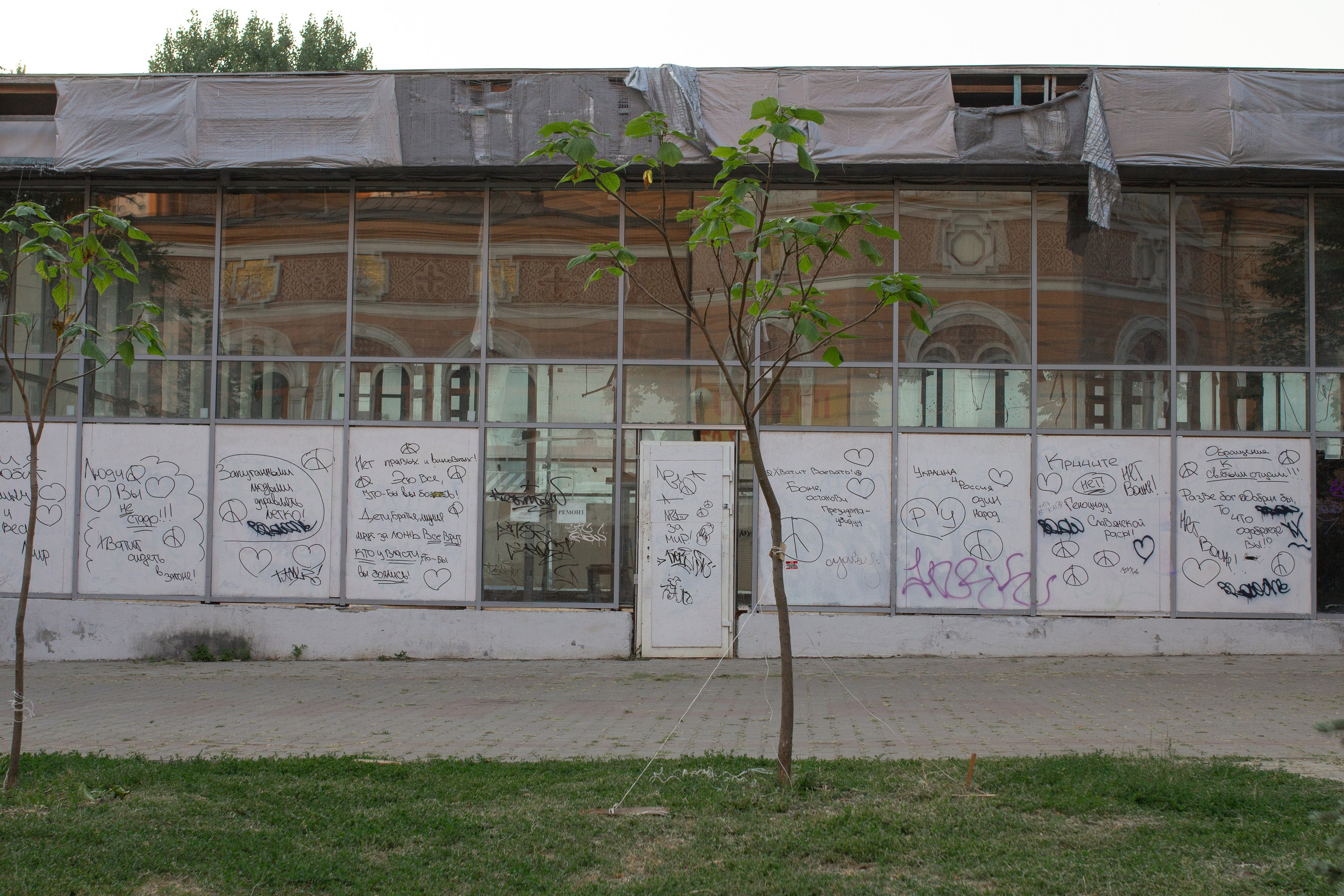 A stall between the Federal Penitentiary Service, a public library with pro-war posters and a temple. On it are written “God stop the murderer president,” “For peace,” “Ukraine and Russia are one people,” “It’s easy to control intimidated people.”