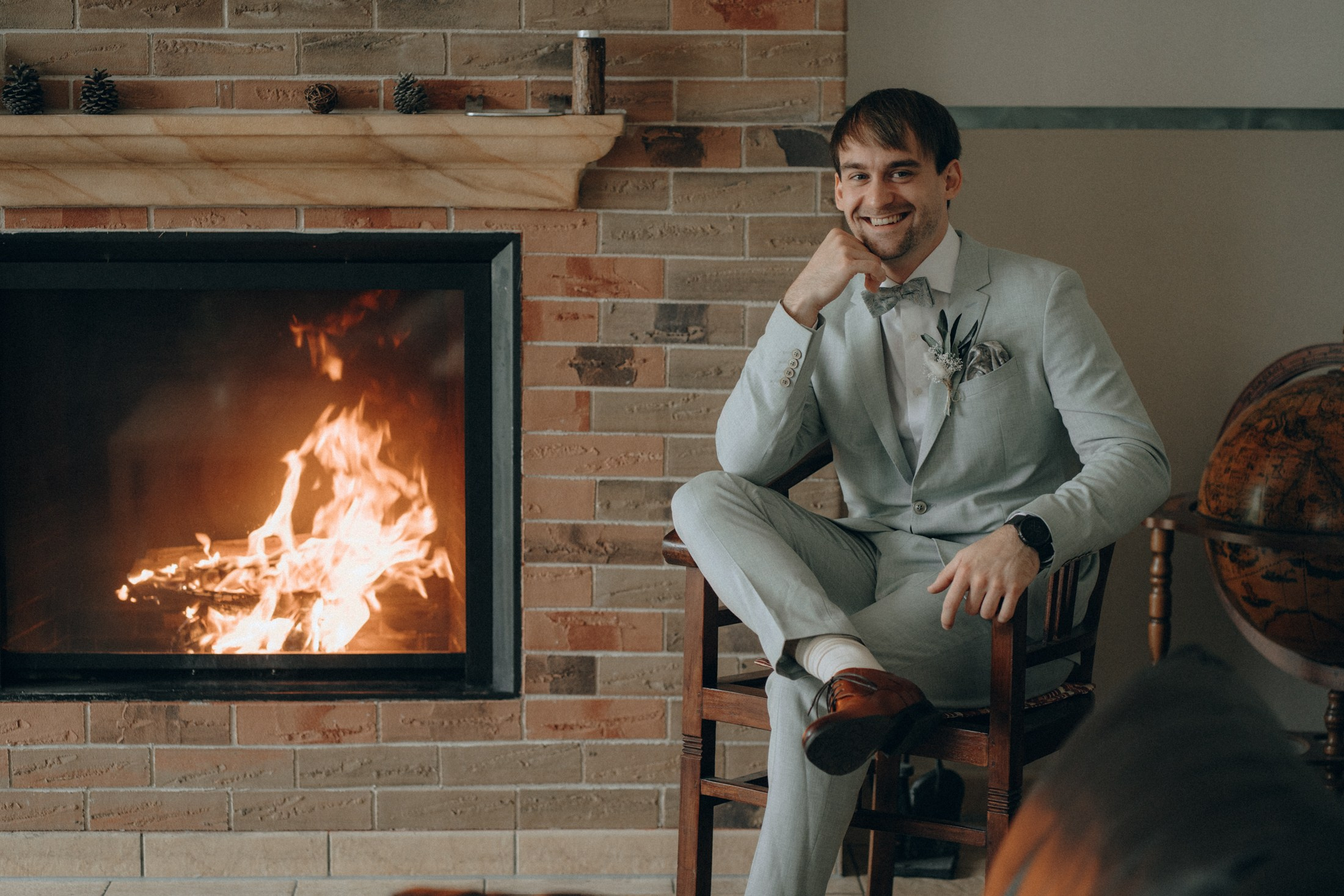 Bräutigam sitzt vor Kamin – stilvolle Hochzeitsreportage Sachsen