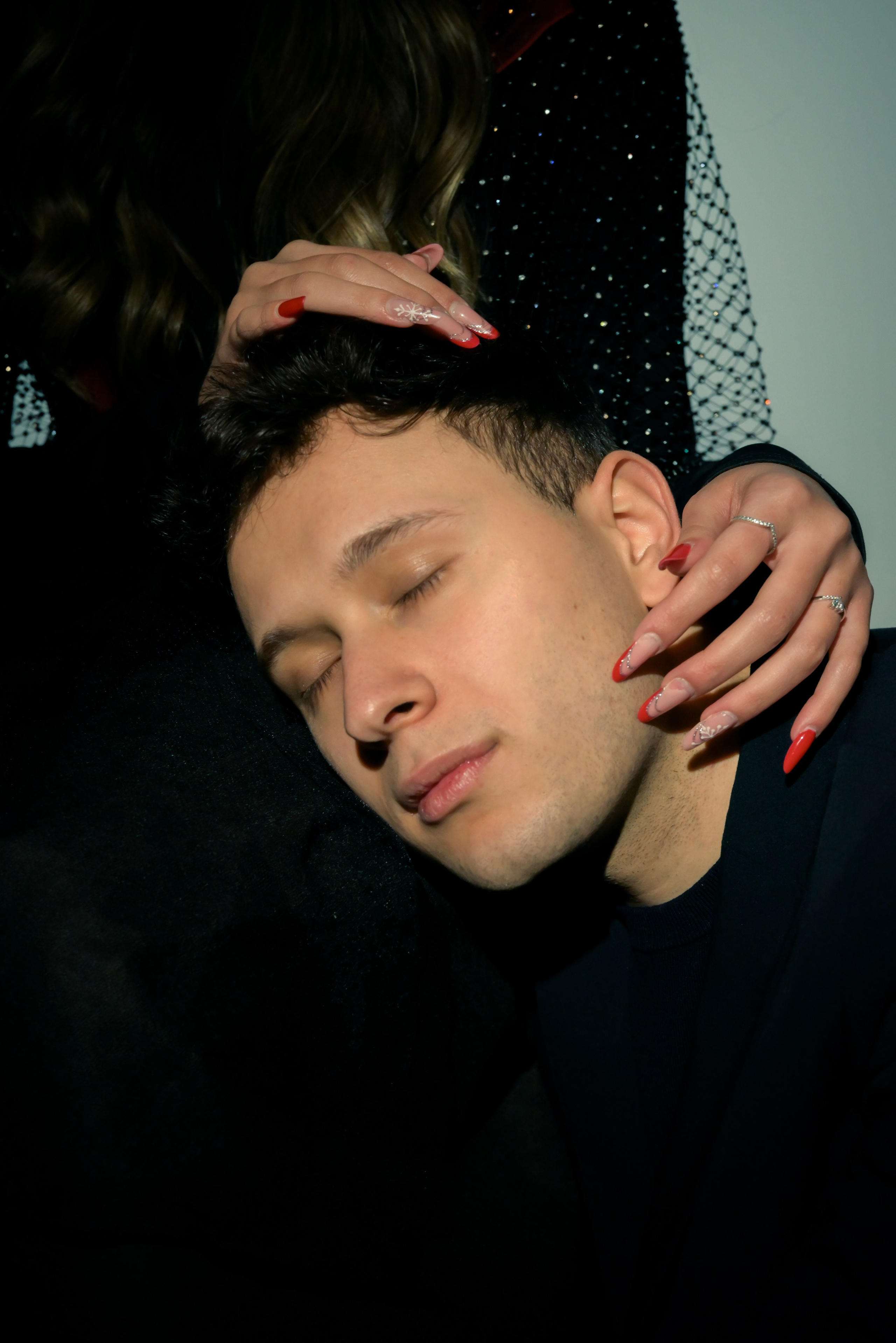 ritratto del ragazzo con le mani della ragazza che lo accarezzano 