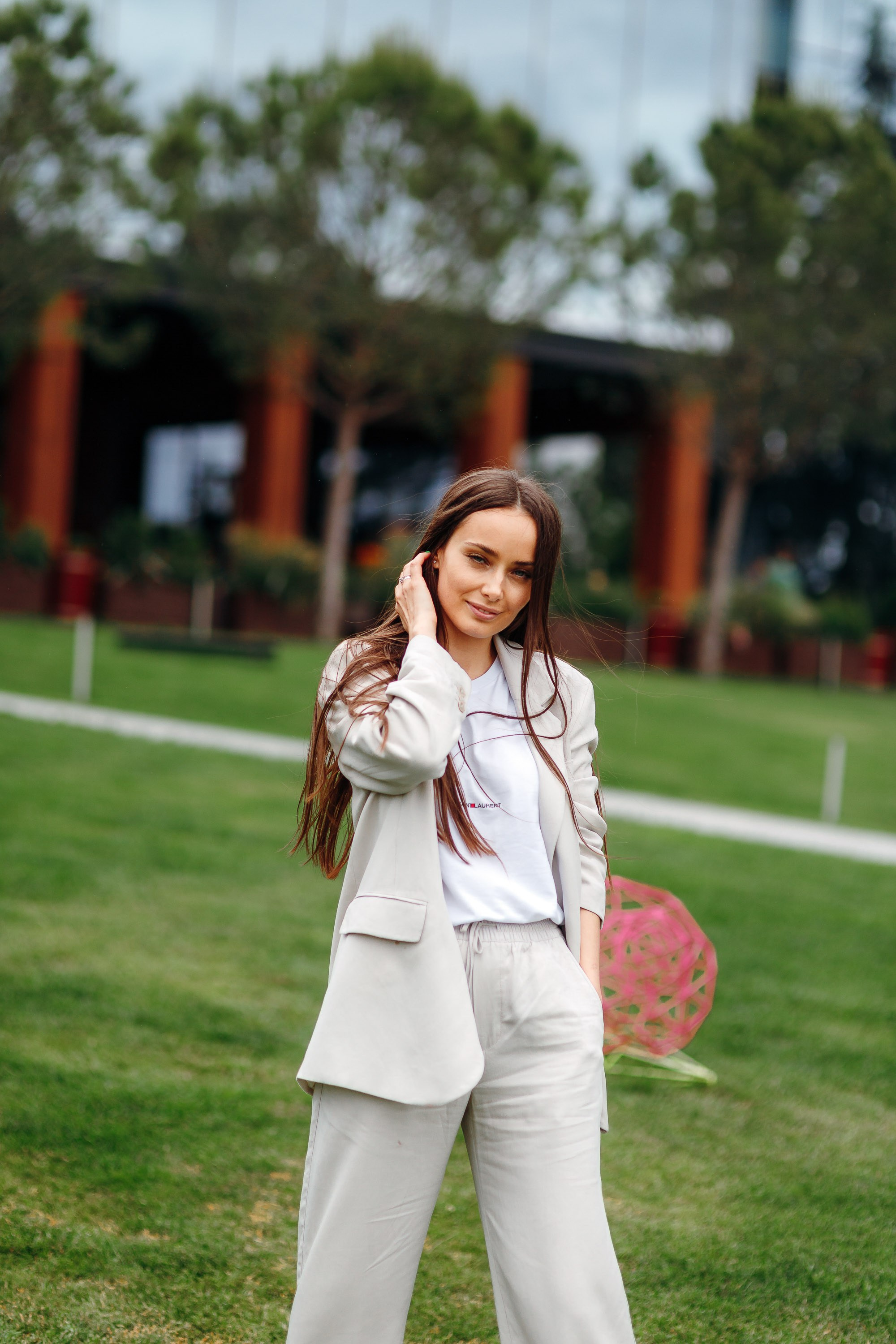 Woman in white outfit posing on green lawn