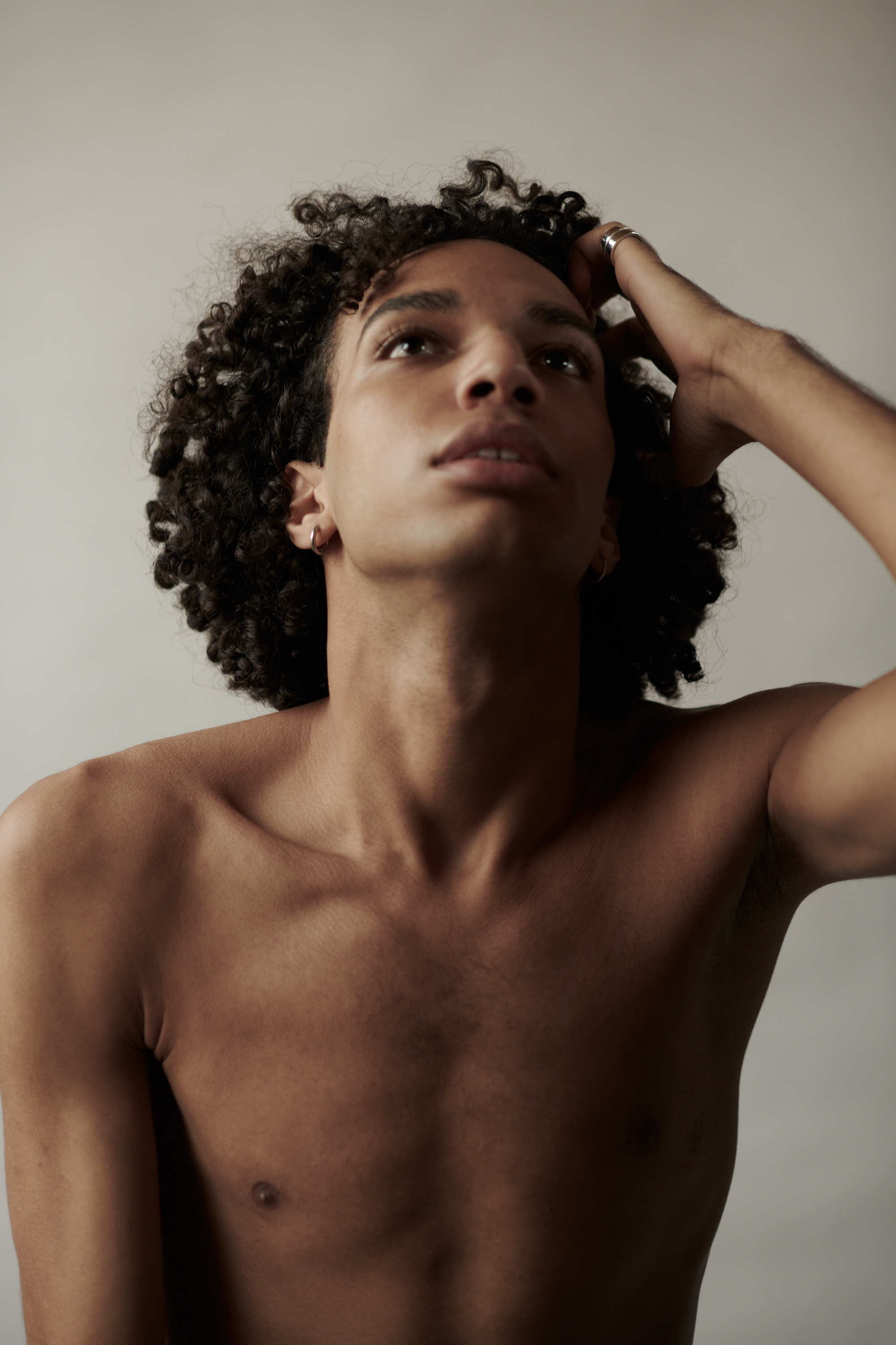 Studioportret van een jonge man met krullen. Fotograaf Amsterdam - Victoria Ushkanova