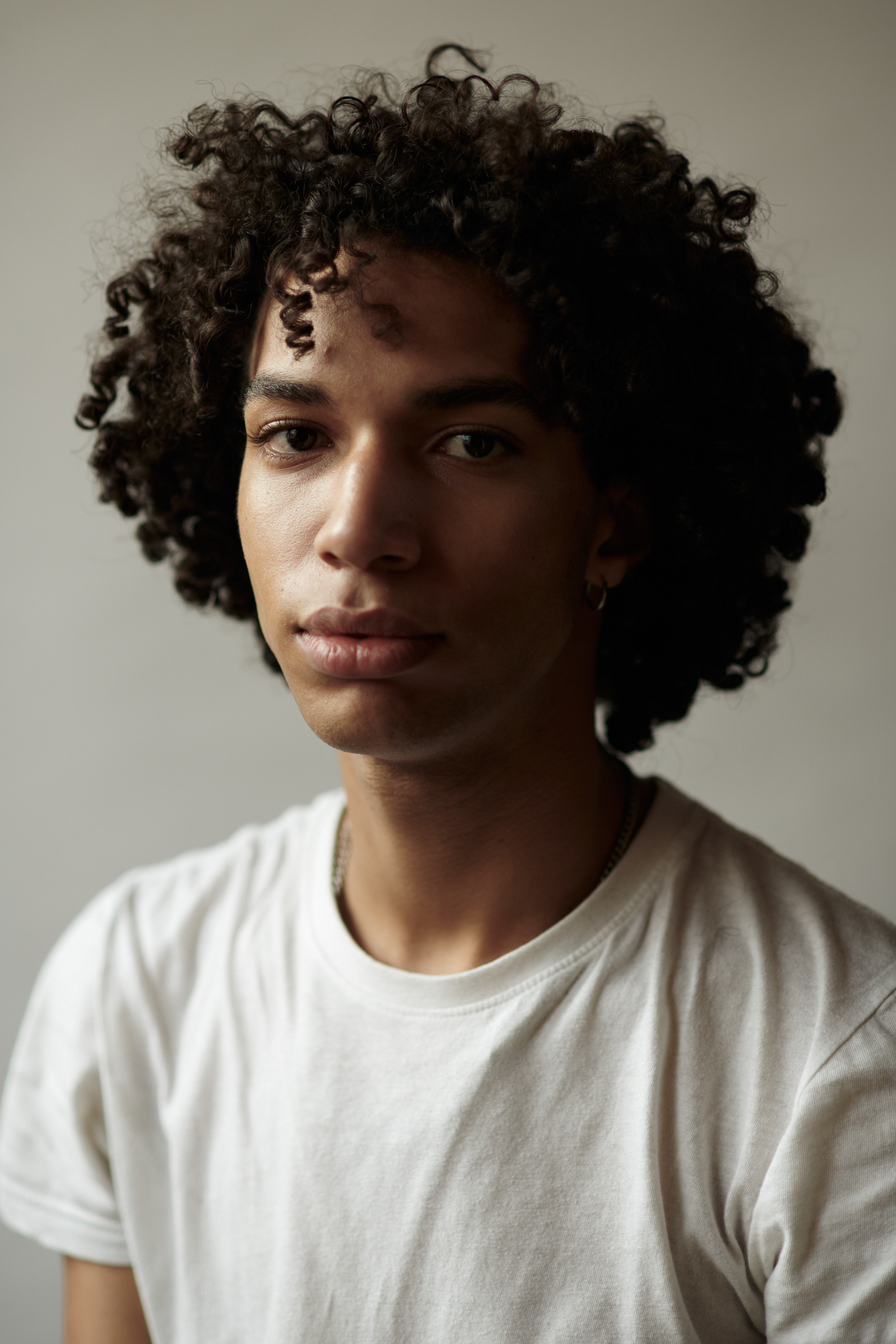 Studioportret van een jonge man met krullen. Fotograaf Amsterdam - Victoria Ushkanova