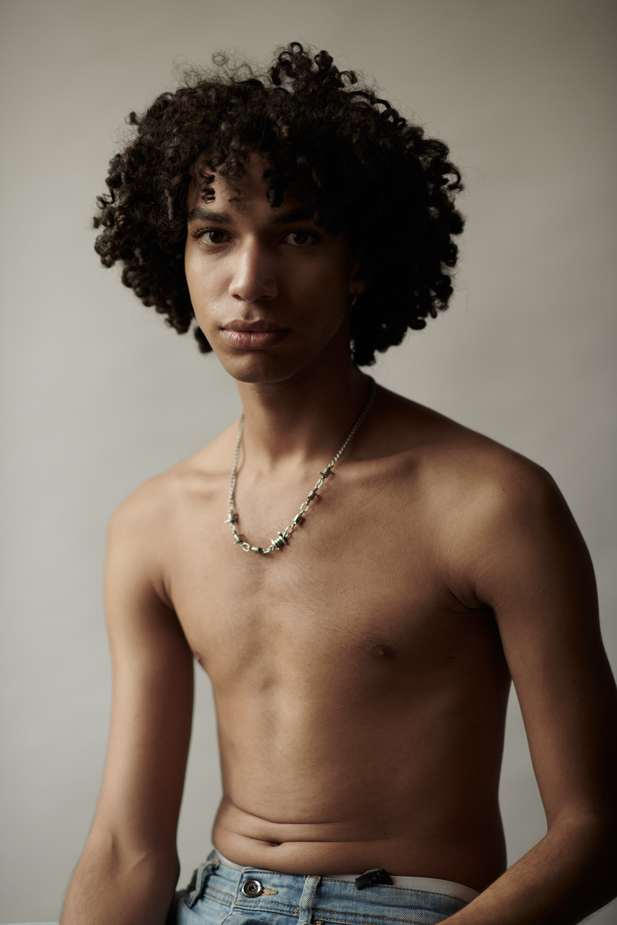 Studioportret van een jonge man met krullen. Fotograaf Amsterdam - Victoria Ushkanova