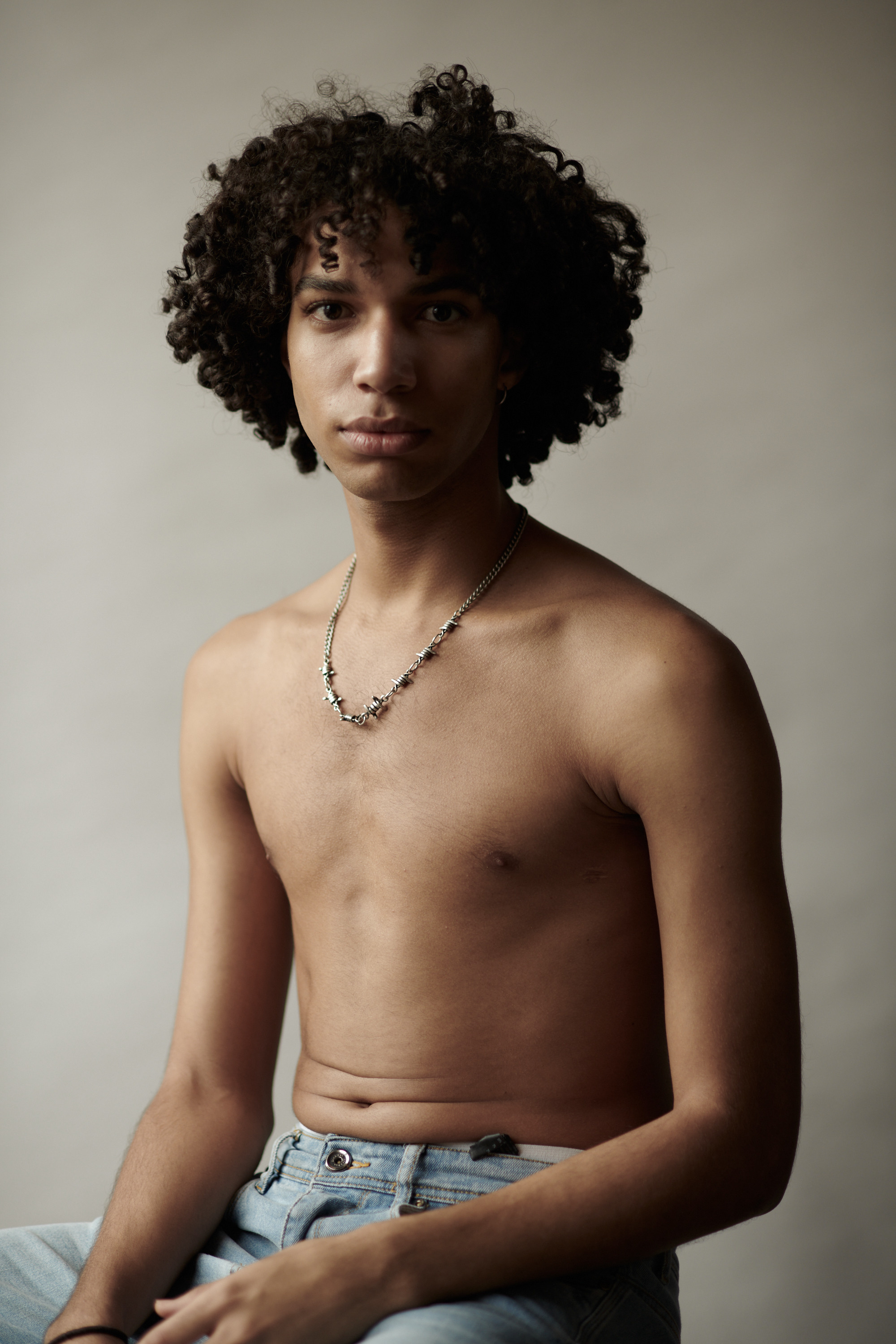 Studioportret van een jonge man met krullen. Fotograaf Amsterdam - Victoria Ushkanova