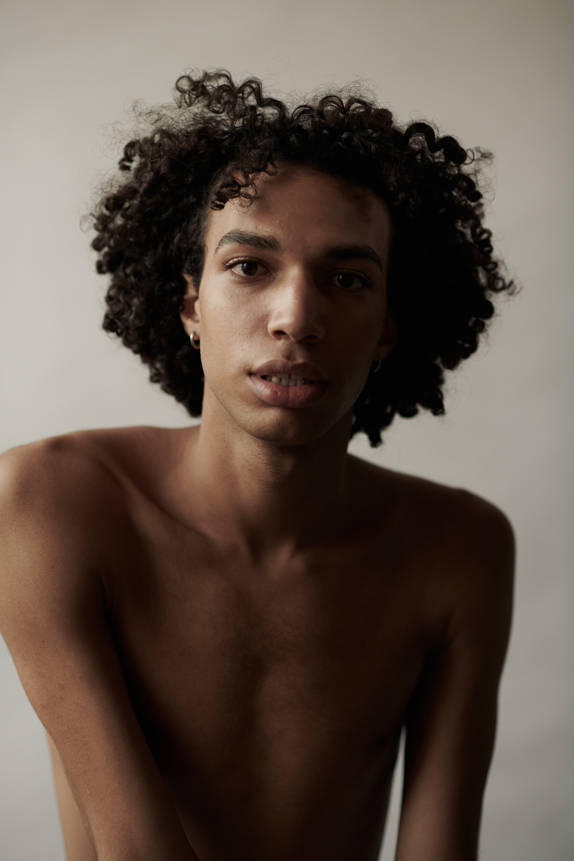 Studioportret van een jonge man met krullen. Fotograaf Amsterdam - Victoria Ushkanova