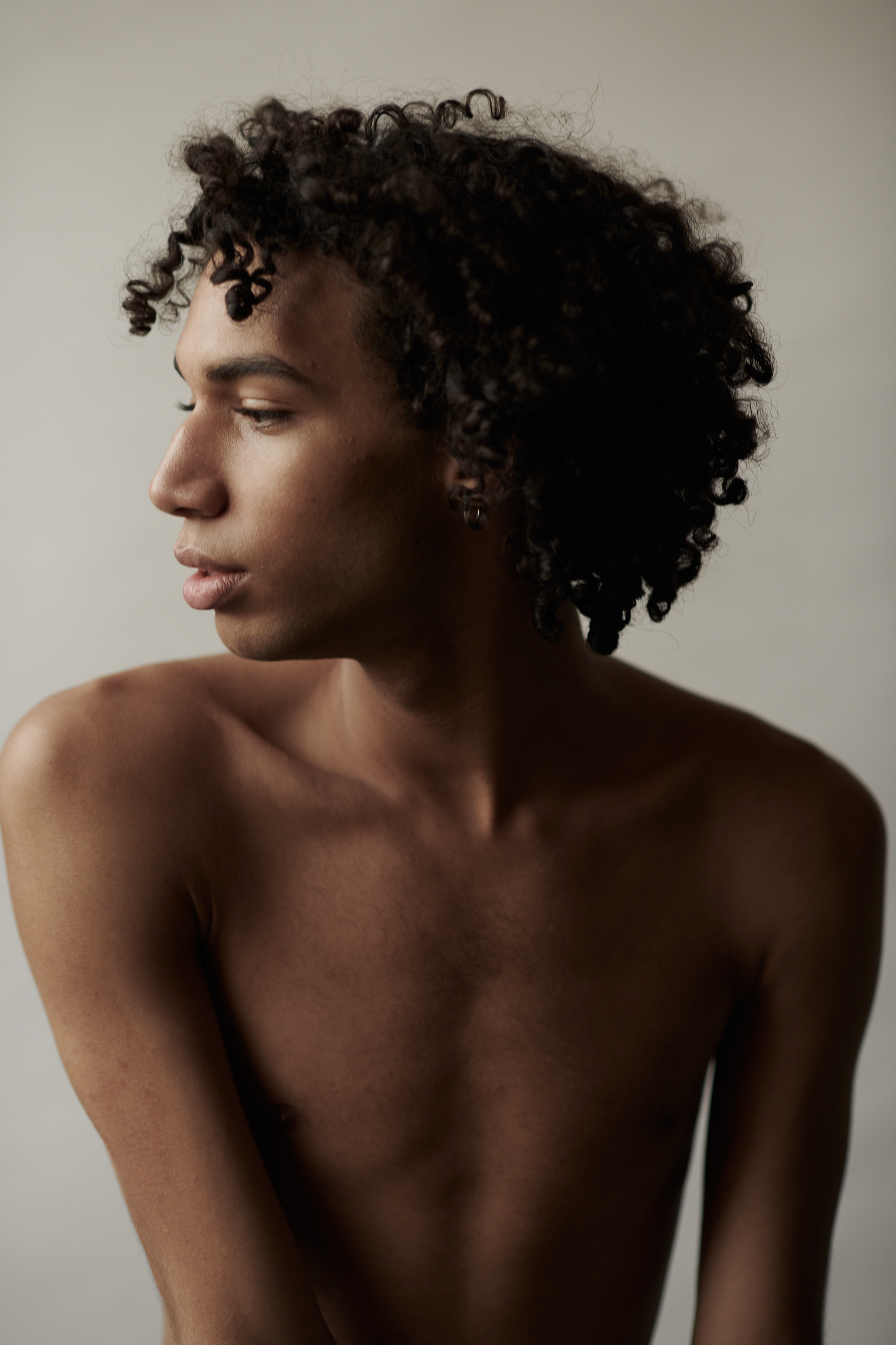 Studioportret van een jonge man met krullen. Fotograaf Amsterdam - Victoria Ushkanova