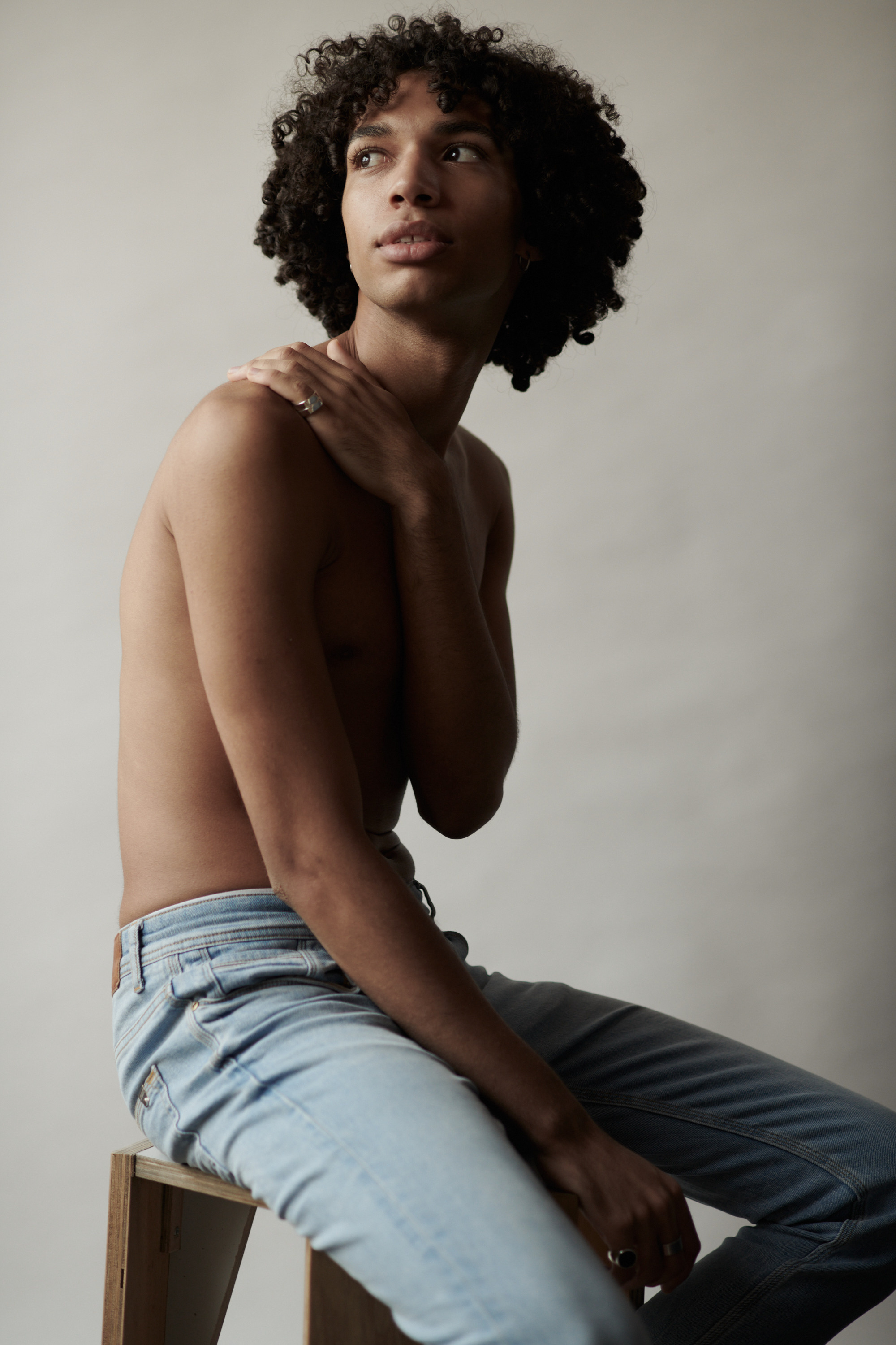 Studioportret van een jonge man met krullen. Fotograaf Amsterdam - Victoria Ushkanova