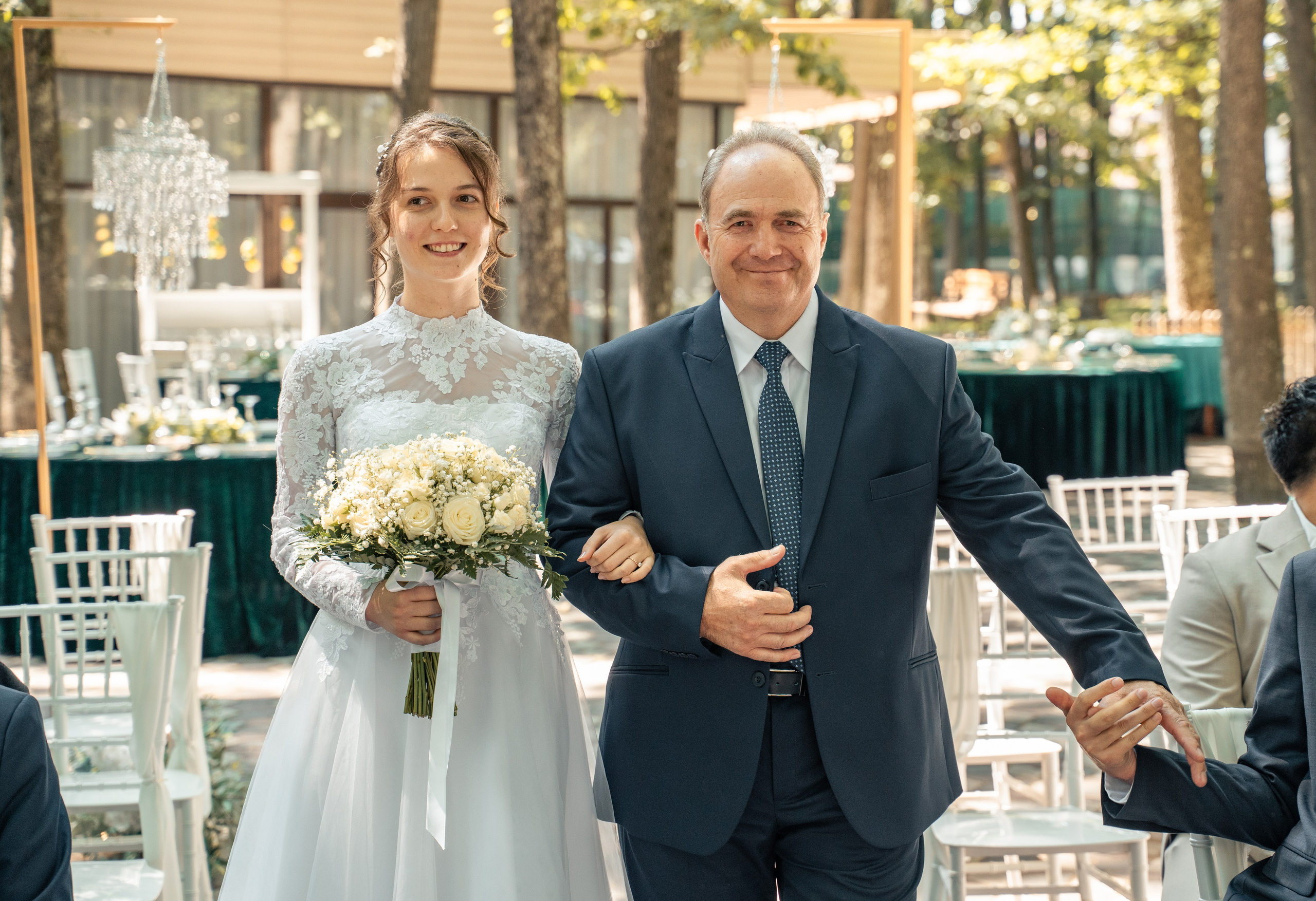 Mireasă intrând la ceremonia de nuntă la brațul tatălui, cadru emoționant în aer liber, nuntă în pădure București, fotograf profesionist de evenimente, incadru.ro.