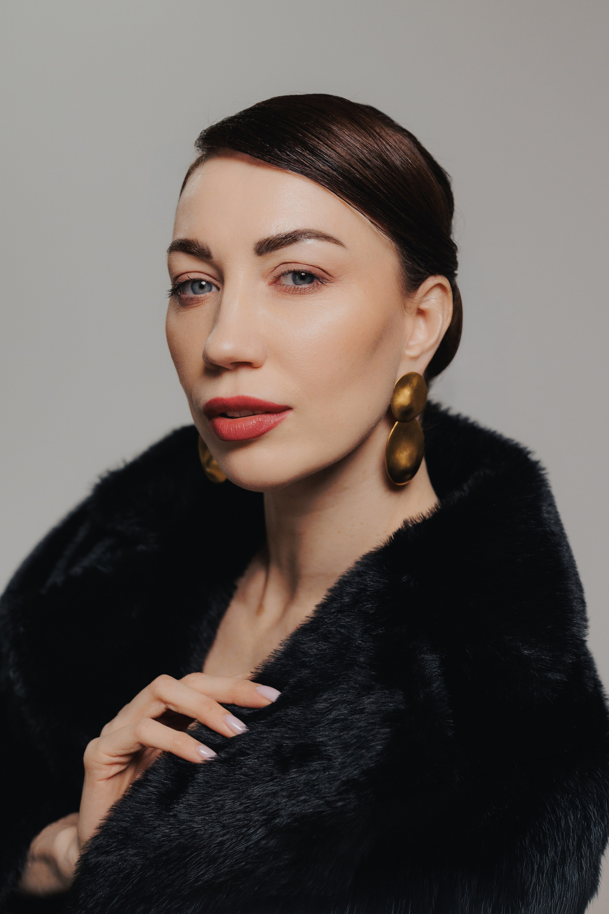 Artistic studio portrait of a woman with sleek hairstyle and natural makeup in soft dramatic light. Художественный студийный портрет женщины с гладкой прической и натуральным макияжем в мягком драматичном освещении.