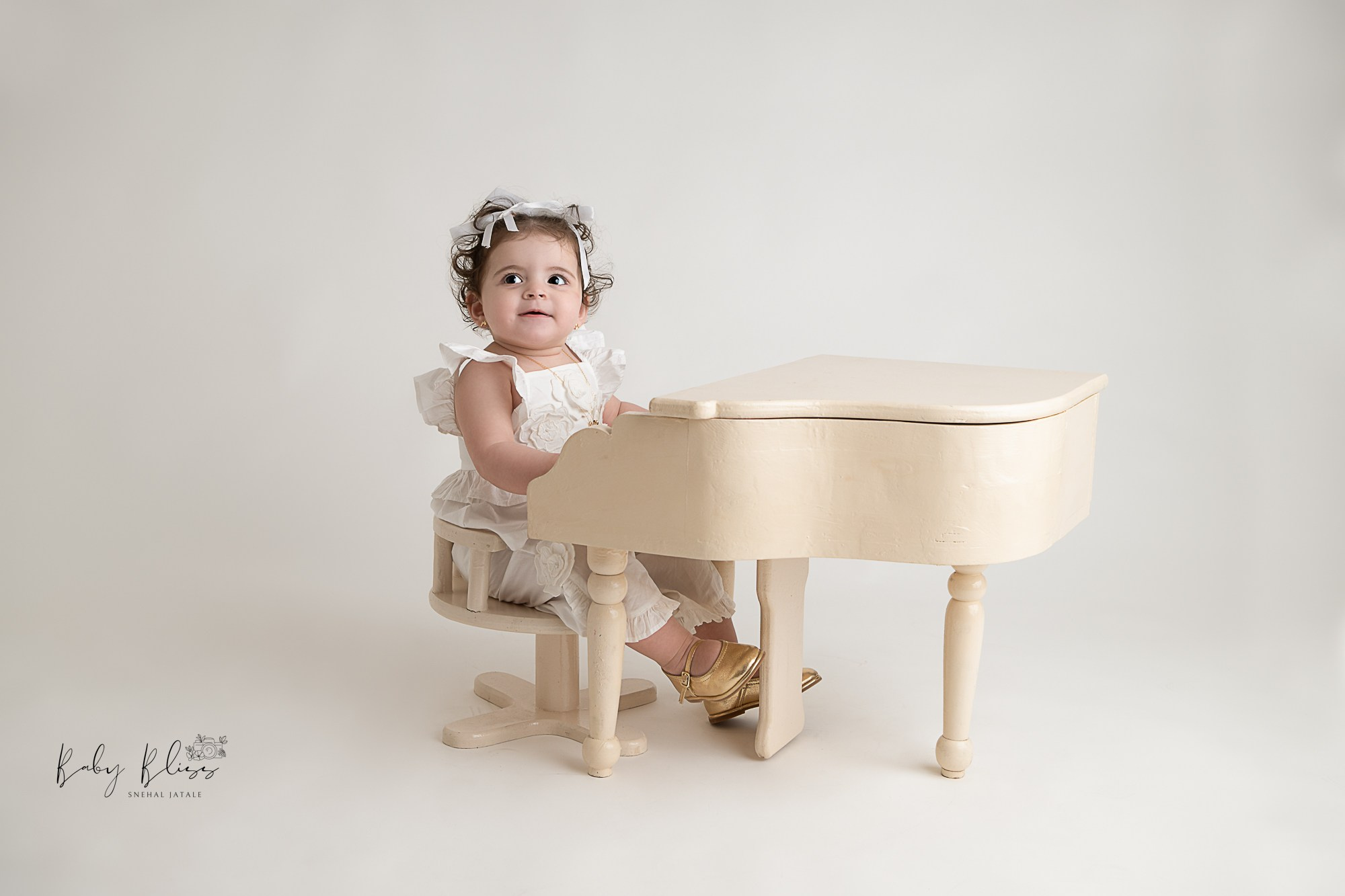 baby girl playing piano, first birthday photo shoot in Doha.
