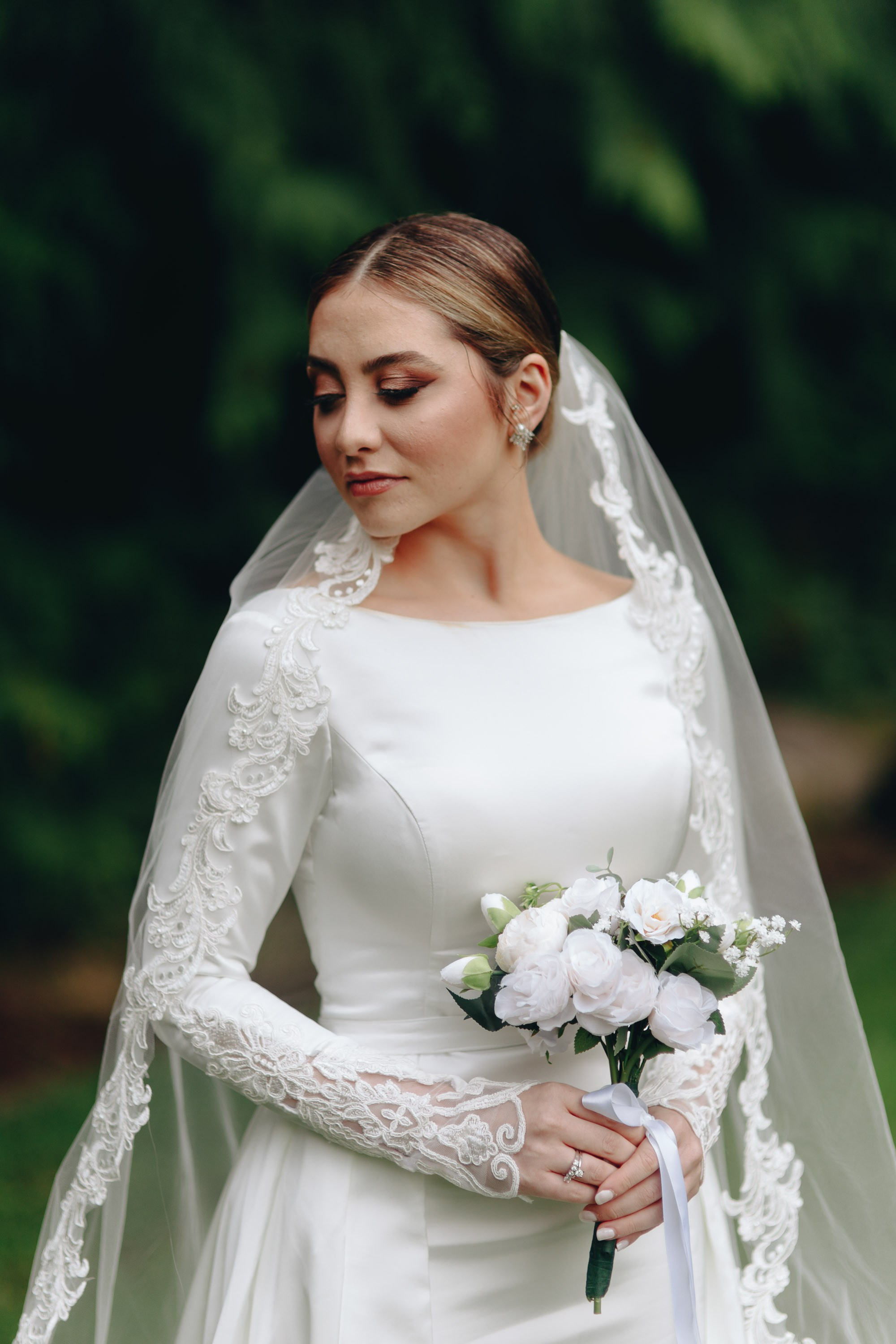Bride in veil holding bouquet, classic wedding portrait