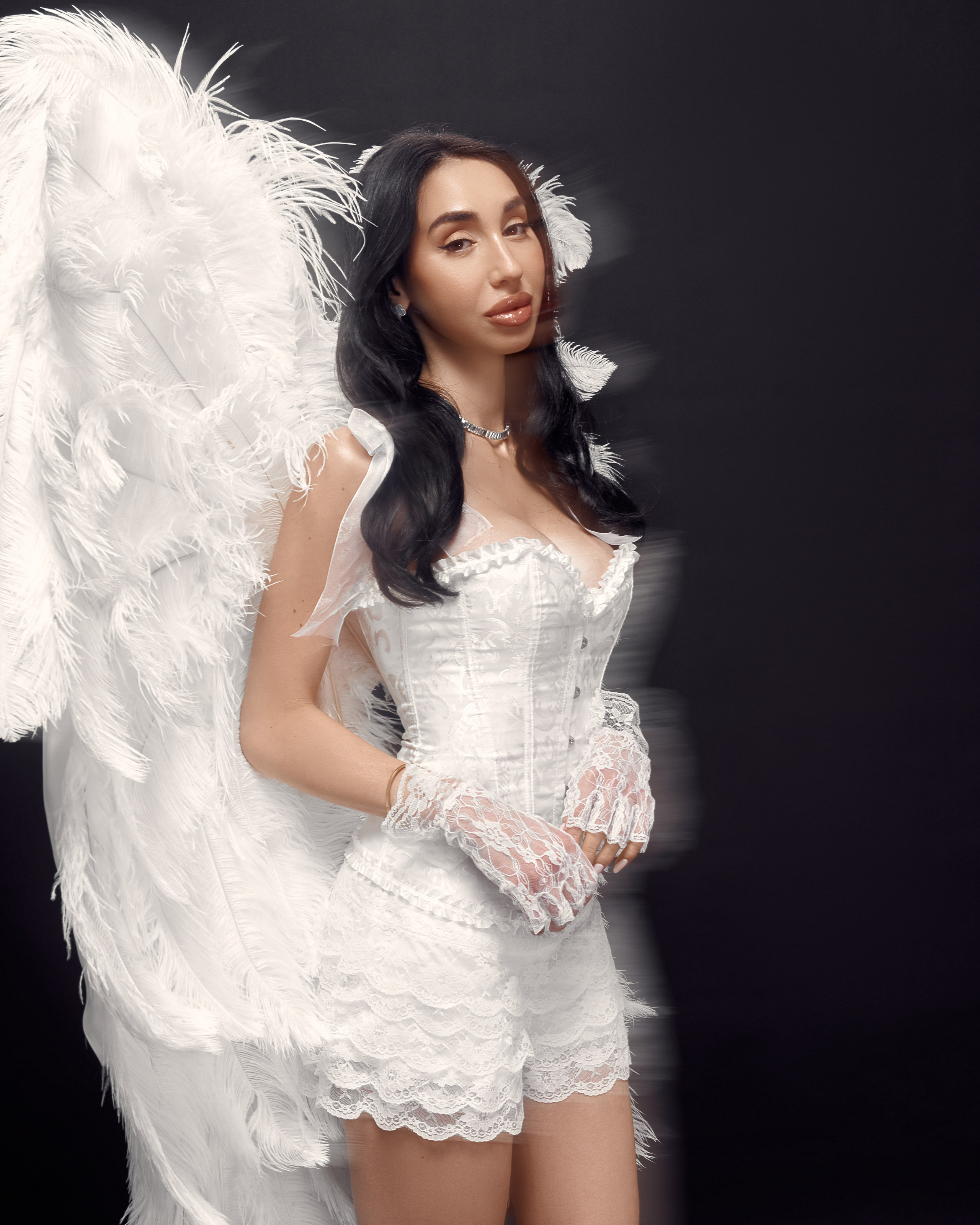 Personal branding studio portrait of blogger Ester Rogovaya with feather wings on a black background