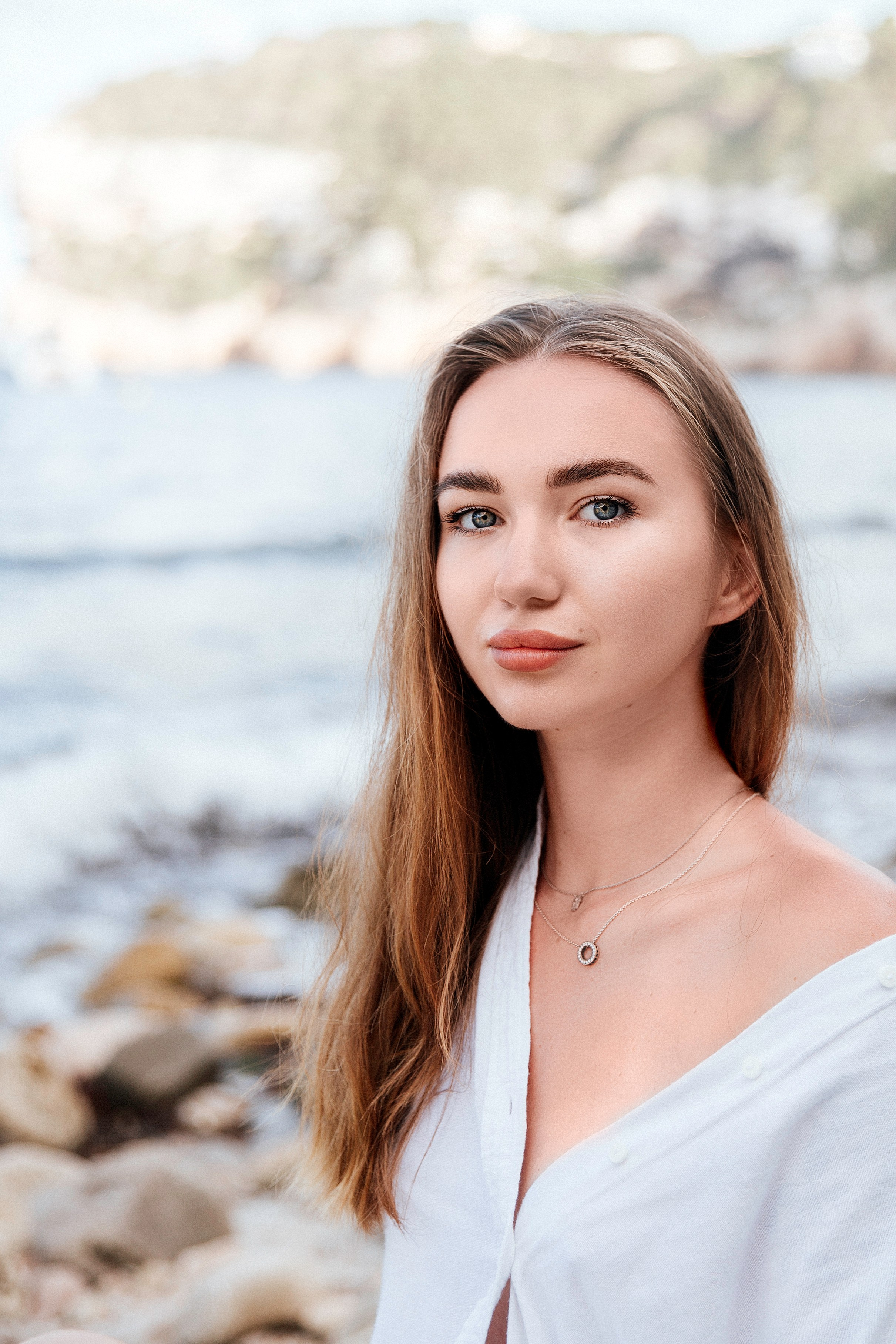 Женская фотосессия в Валенсии, Испания, с естественным уличным портретом женщины у моря, с мягким средиземноморским светом, спокойным выражением лица и прибрежным пейзажем на фоне — идеально для женской портретной фотографии, лайфстайл-съёмок и профессиональных женских фотосессий в Валенсии и по всей Испании.