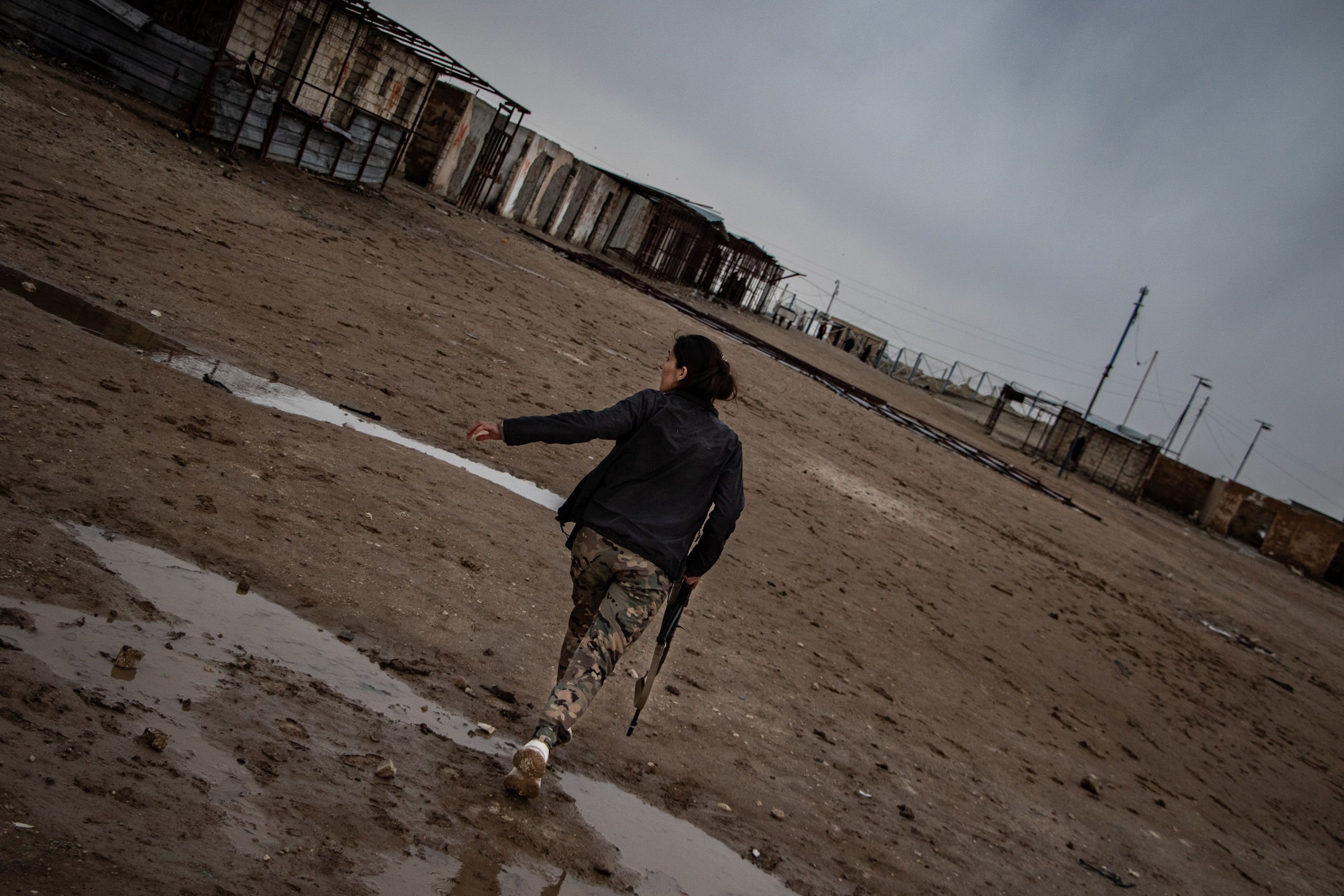 Une garde kurde court après avoir reçue des pierres dans la section étrangère du camps Al-Hol, prisonniers de Daesh, dans le Rojava Kurdistan Syrien.