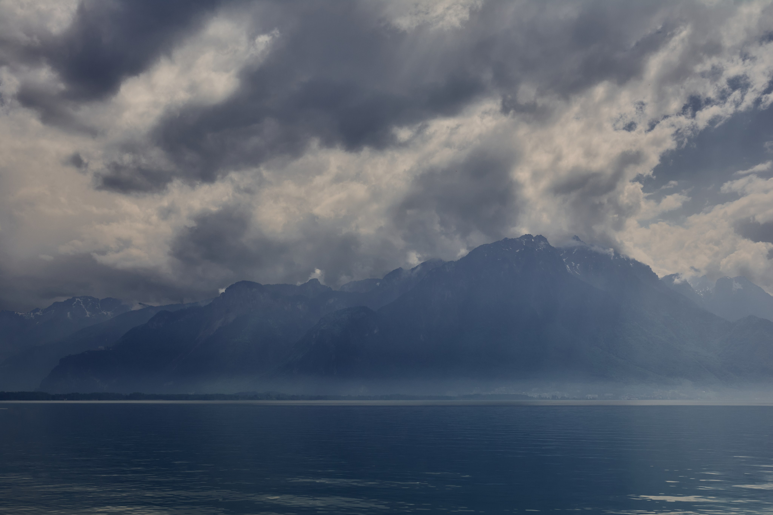 Dramatic storm clouds over alpine lake landscape