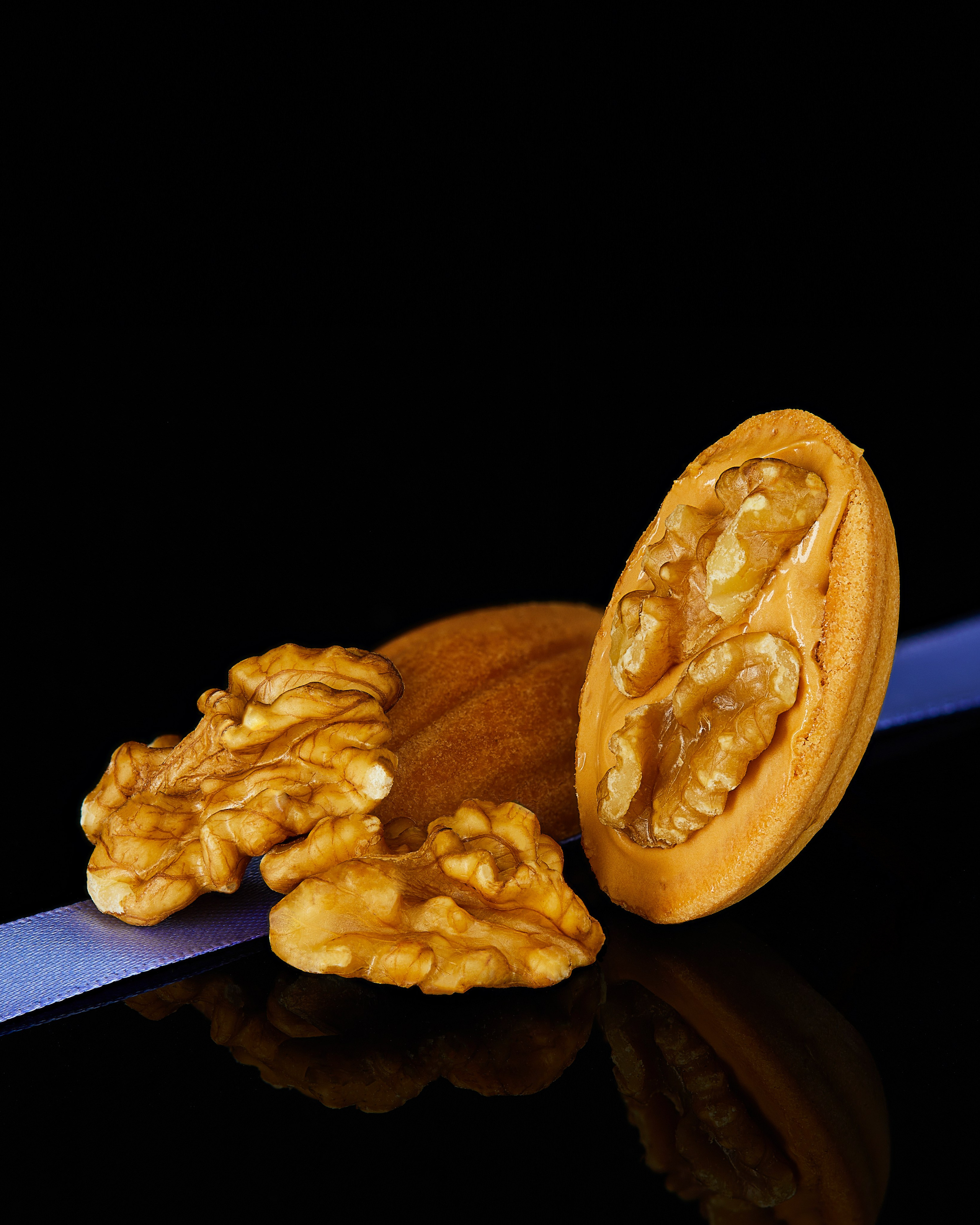 Photographer Roman Djuzev - Cookies "Nuts" with boiled condensed milk and walnuts plan on a dark background.
