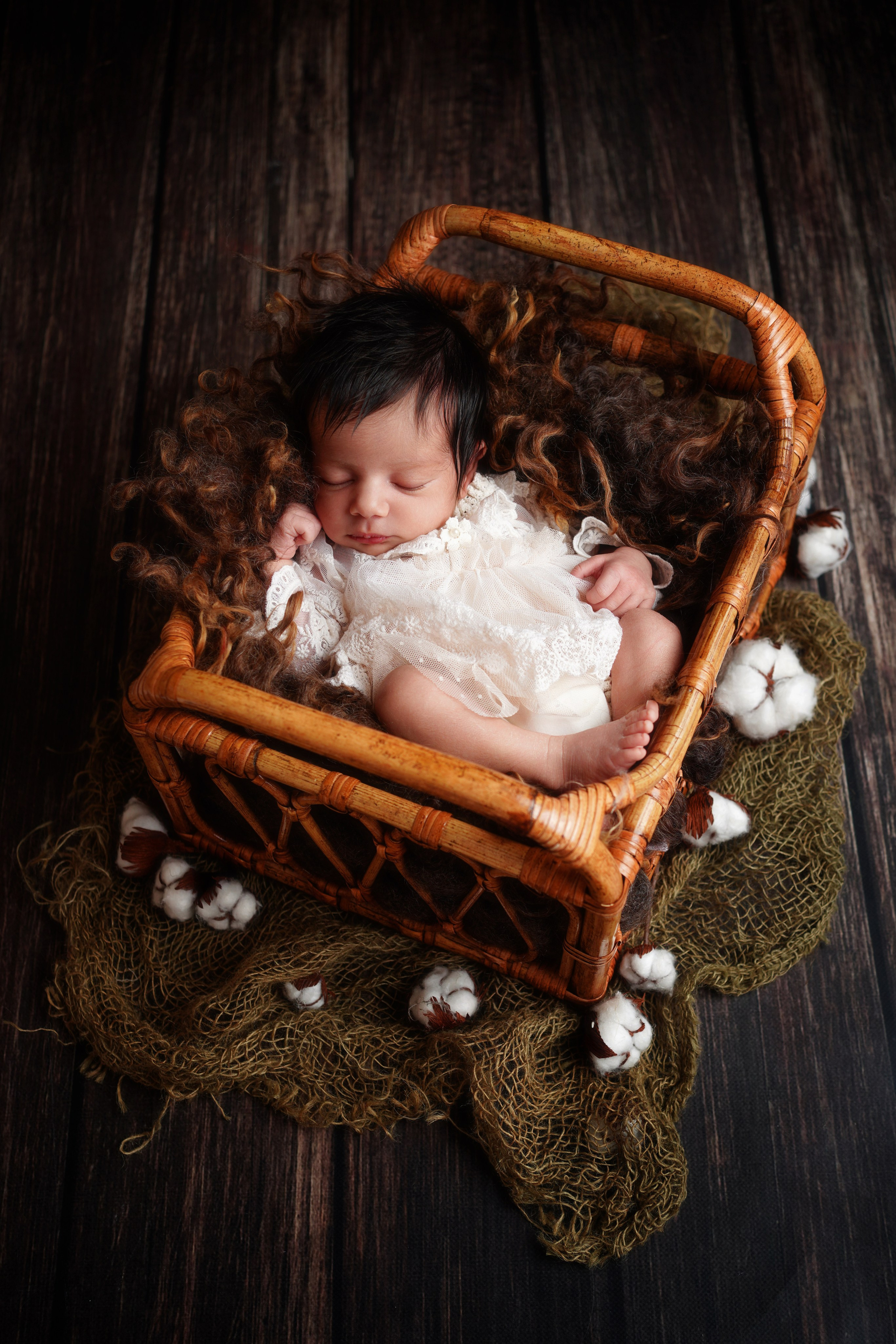 Die Anmut eines schlafenden Neugeborenen, umgeben von zarten Textilien, fängt die Schönheit und Unschuld dieser kostbaren Momente ein