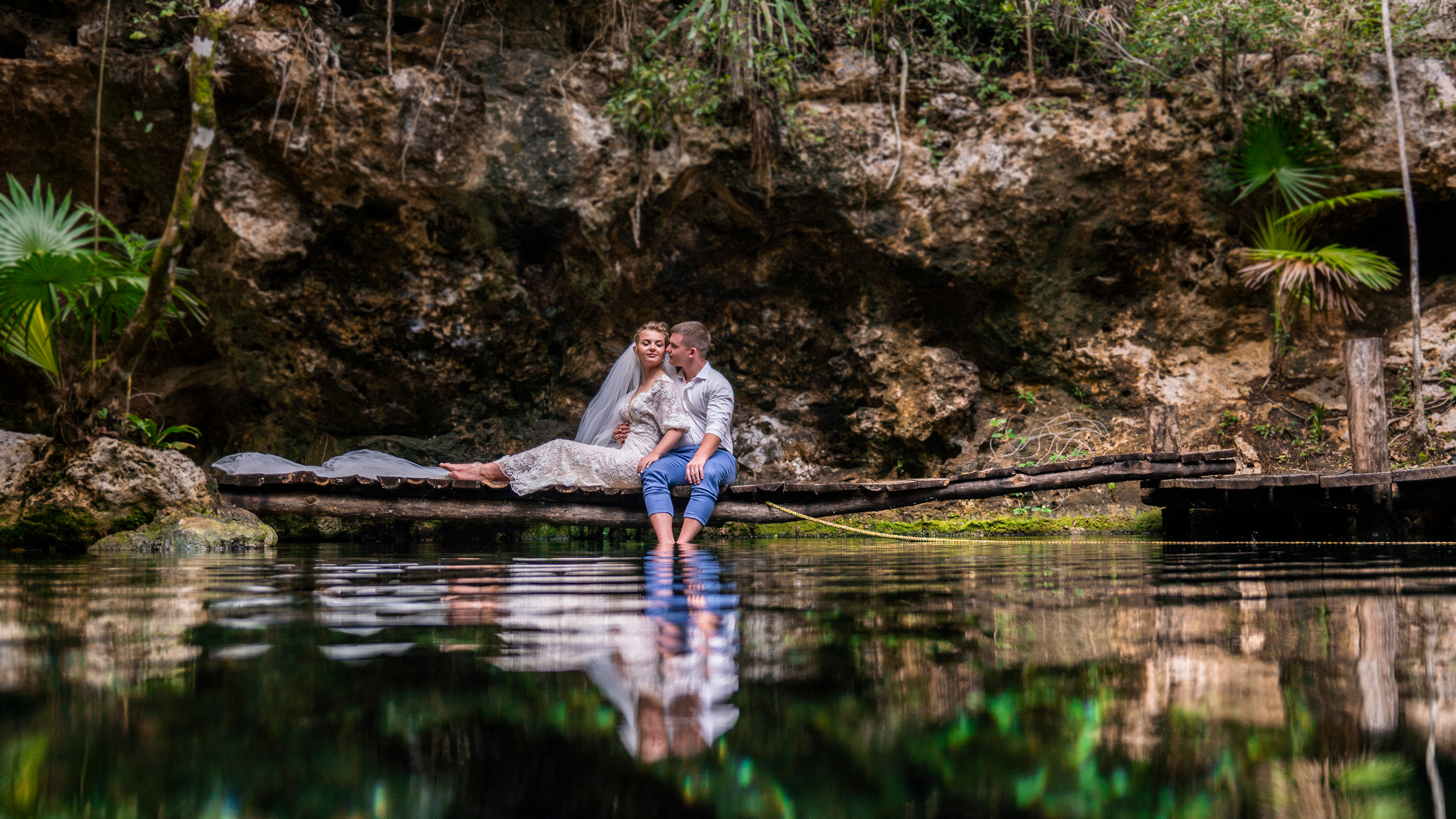 Couple in white surrounded by jungle and turquoise water