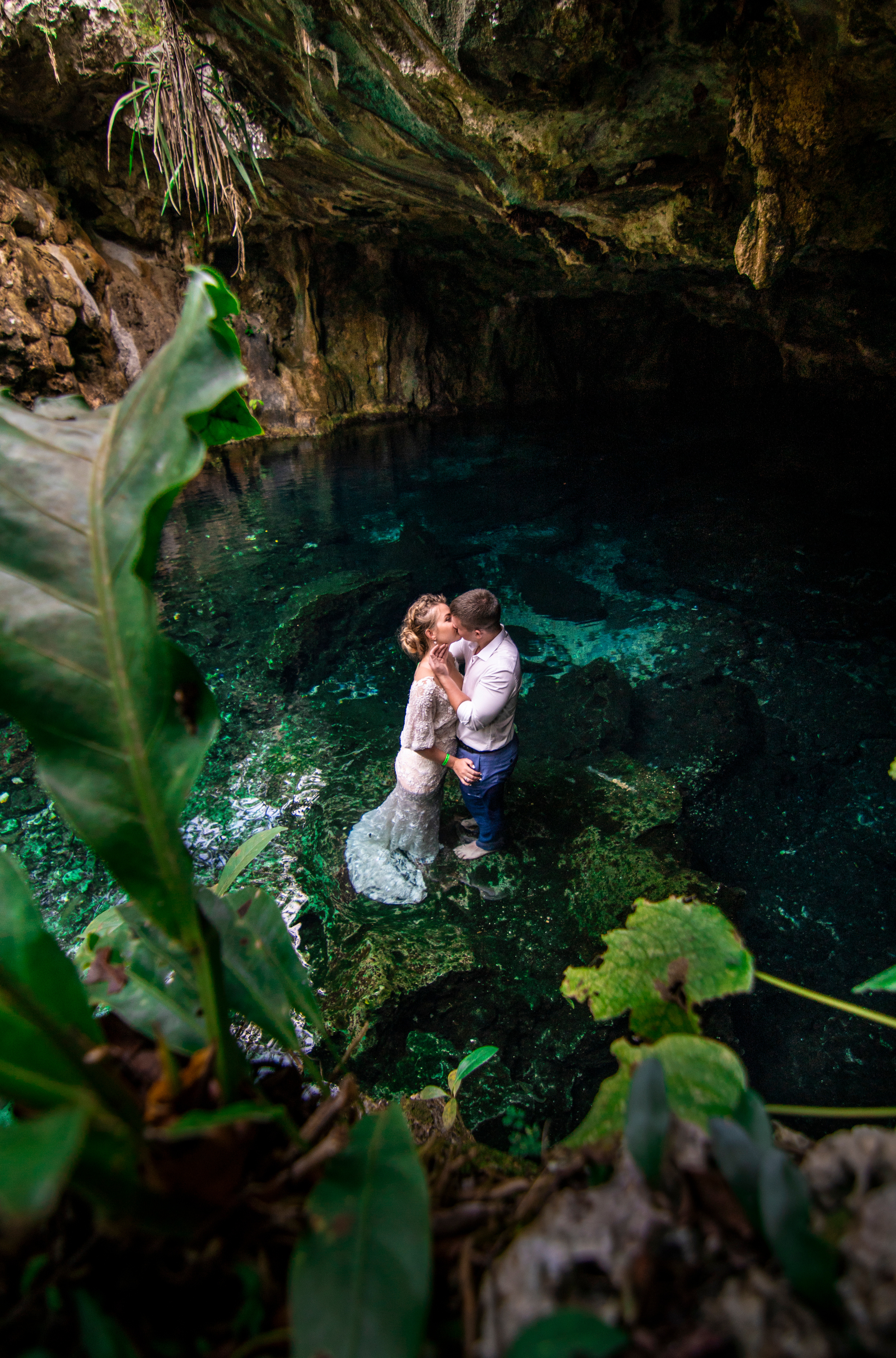 Groom kissing bride at secret cenote wedding venue