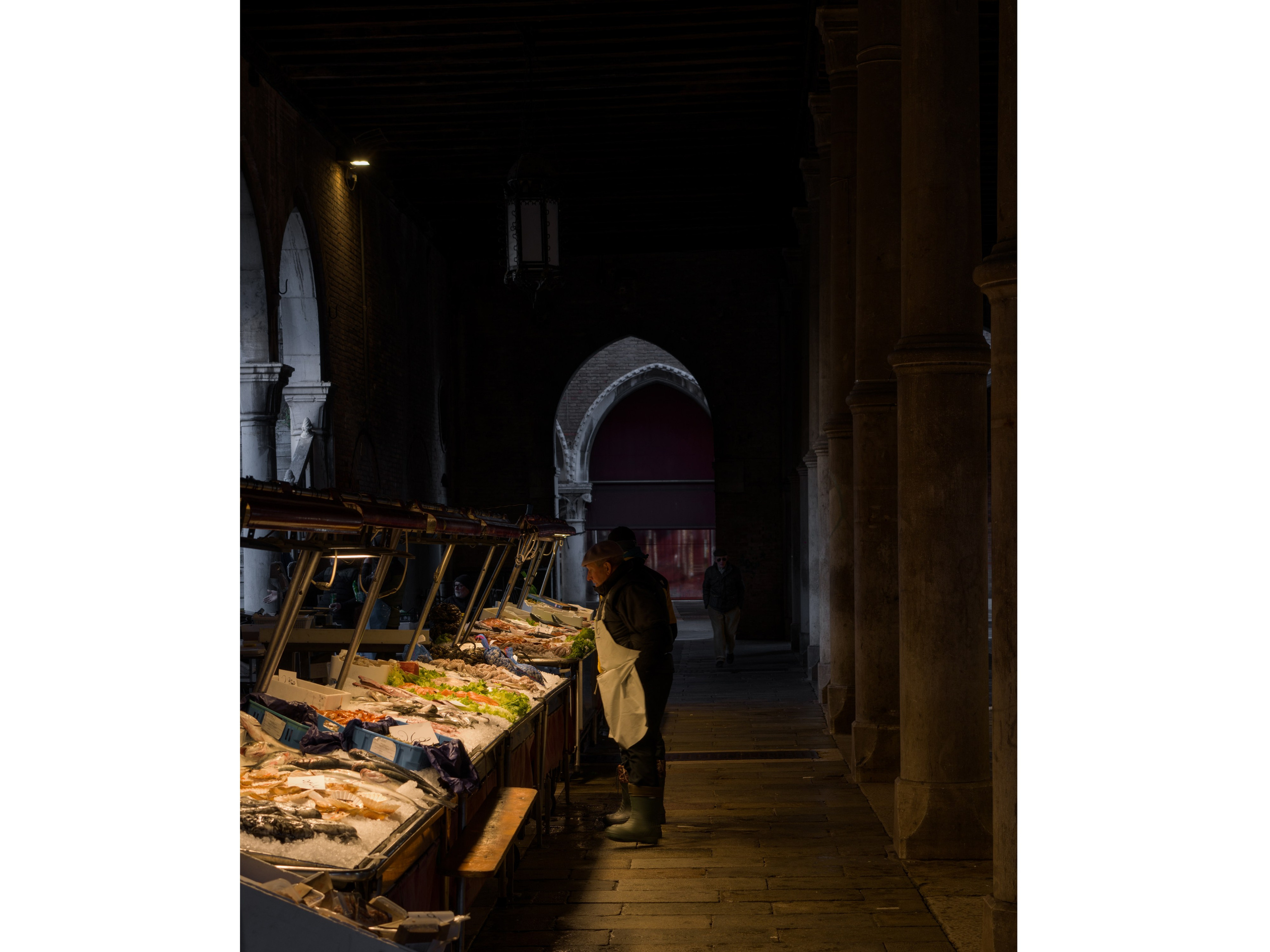 Venetian fish market at dusk with warm light and historic arcade