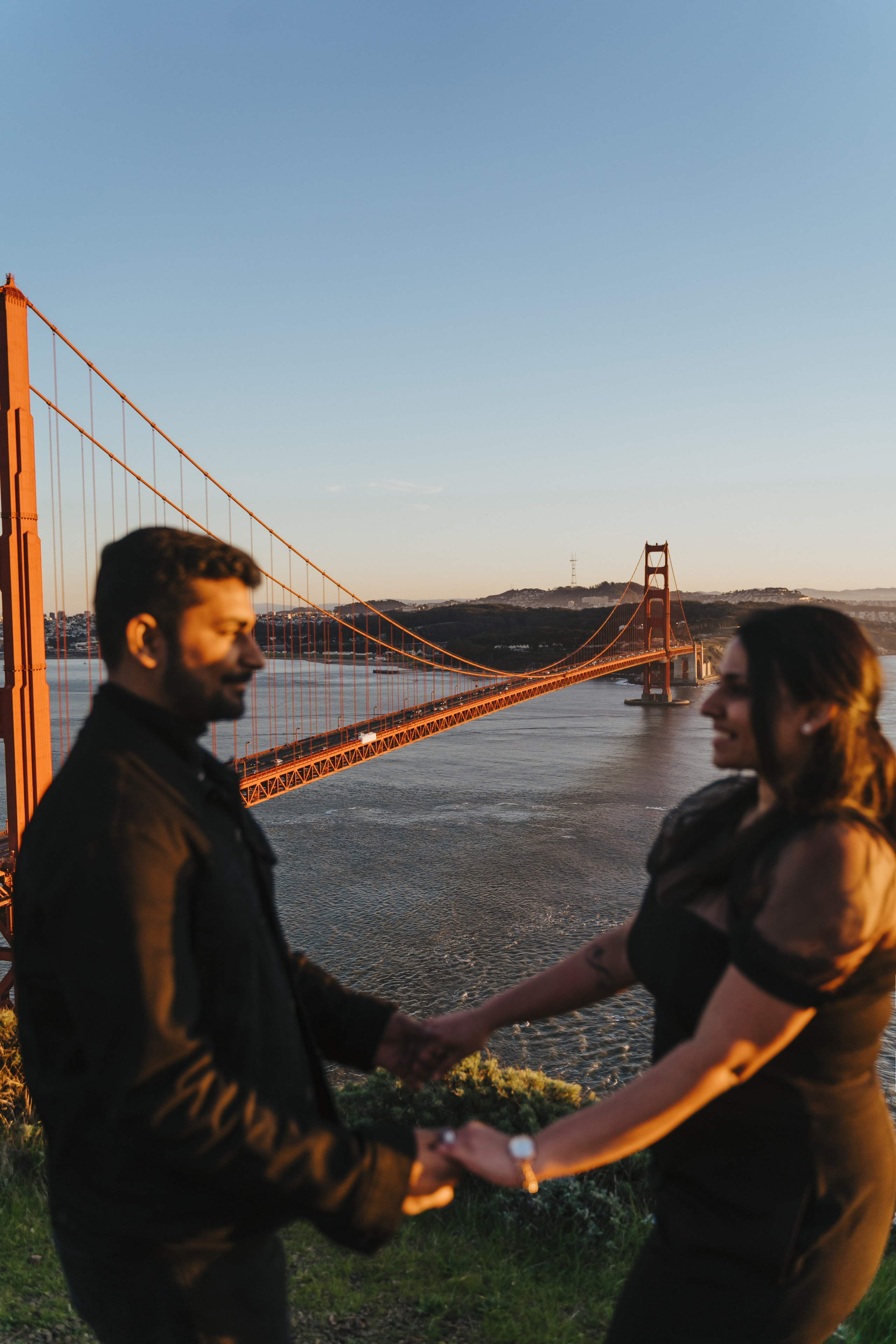 Proposal.  Overlooking the golden San Franisco Bridge sunset with a couple. Photographer Video. 