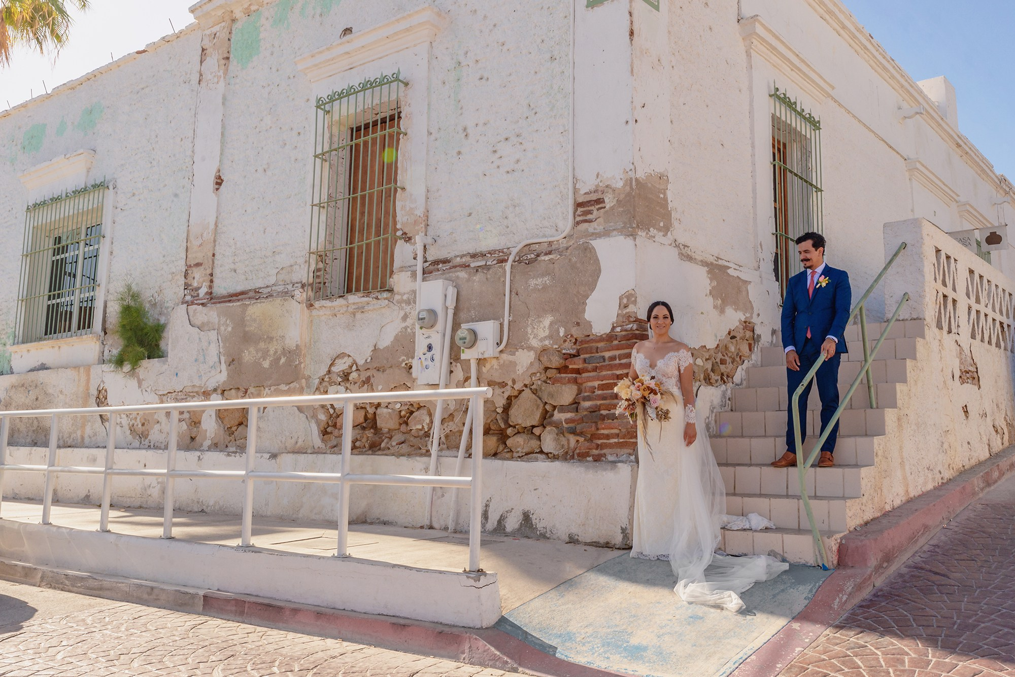 Wedding photoshoot in downtown San Jose del Cabo – bride and groom portrait with colonial architecture and ocean view