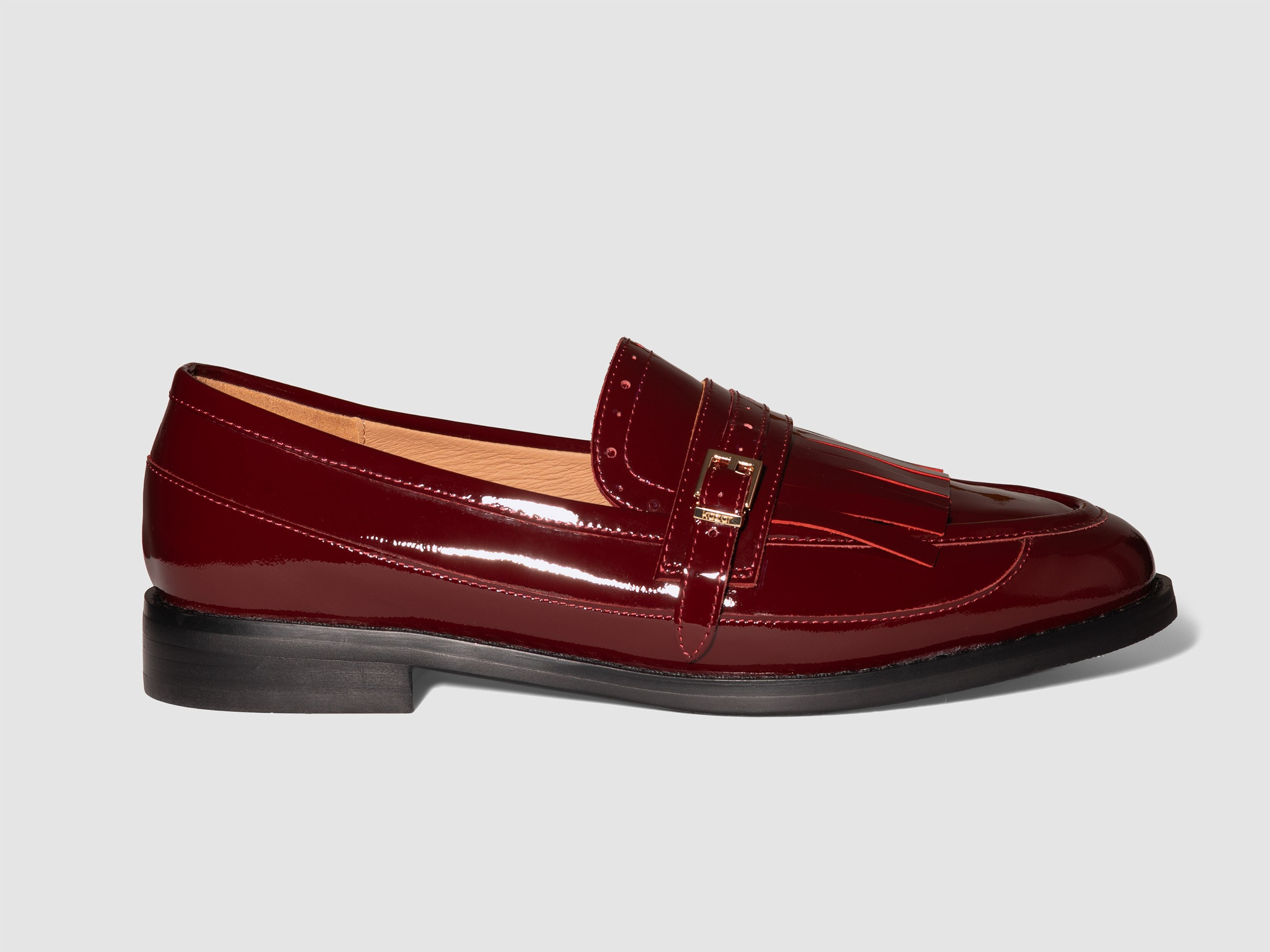 Burgundy patent loafers side view white background footwear photography