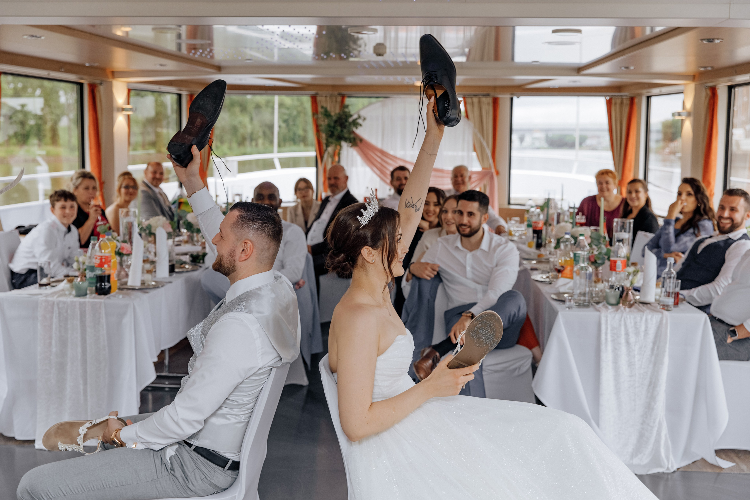 Der Bräutigam und die Braut spielen ein Hochzeitsspiel mit ihren Schuhen. 