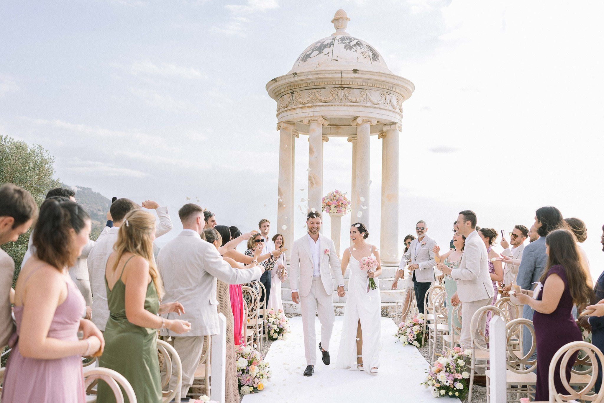 Newlyweds walking through flower petal celebration Mallorca