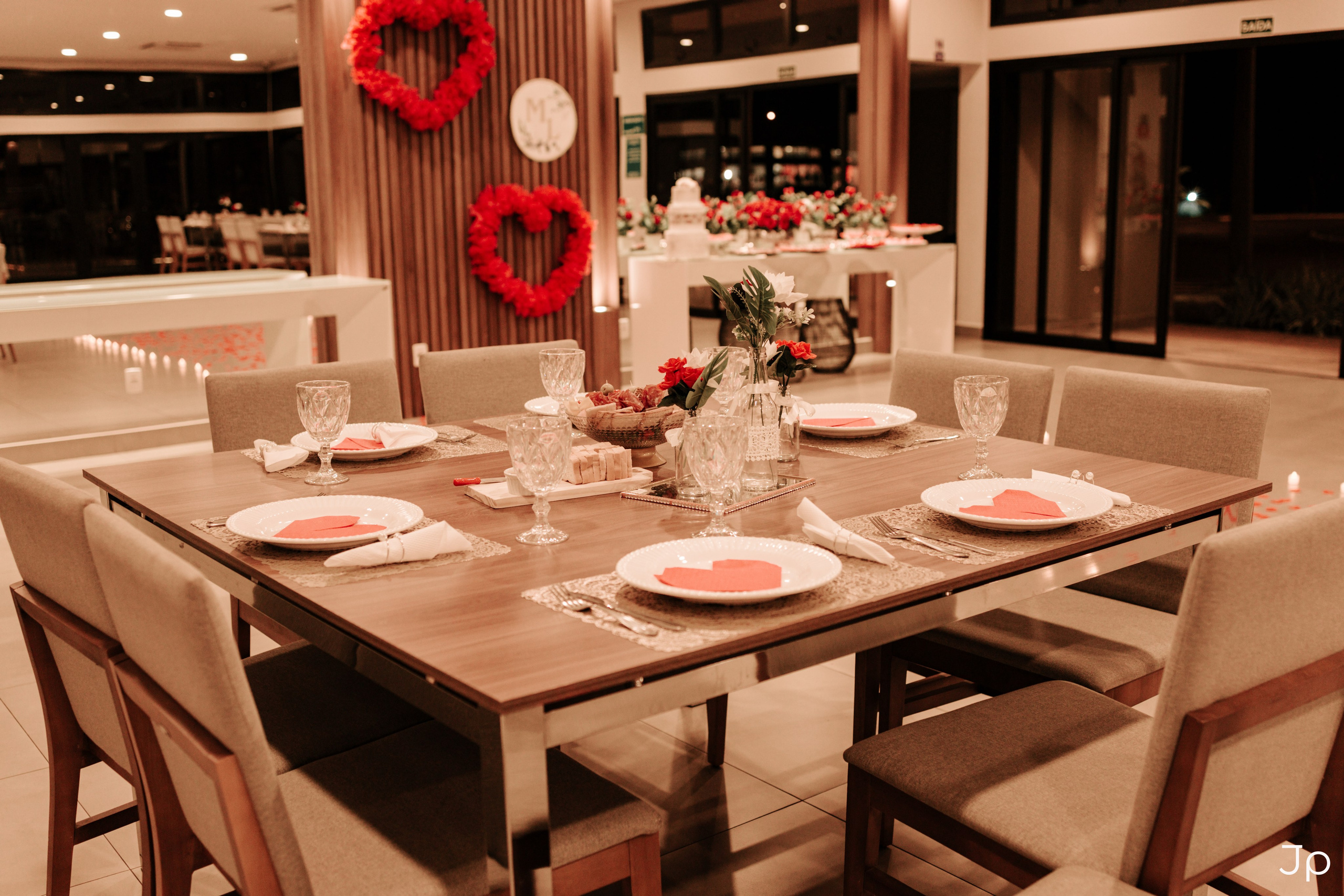 Ambiente decorado com mesa posta e coração na parede.