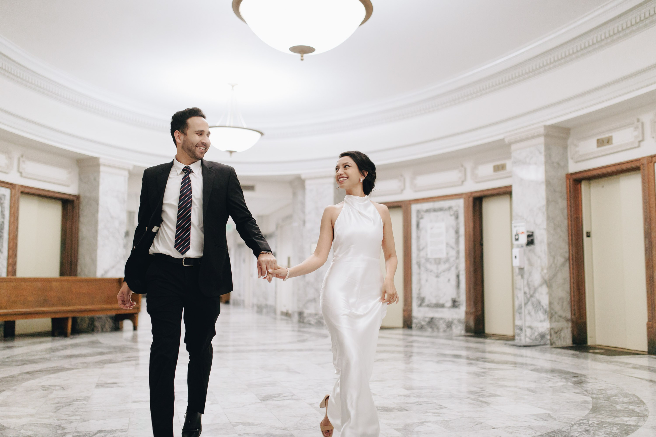 Bride and groom walking indoors, elegant wedding venue