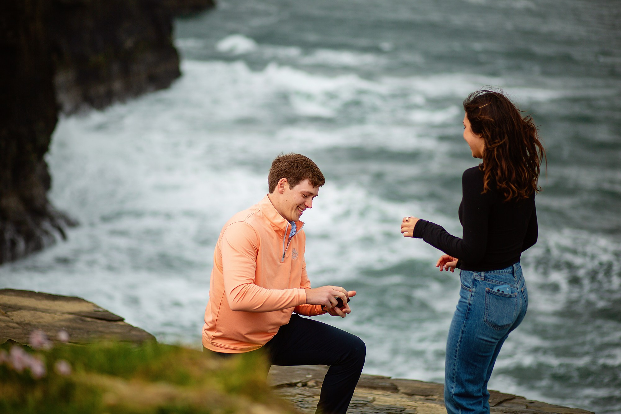 A couple embracing after their engagement on the scenic Irish coast near Dublin.